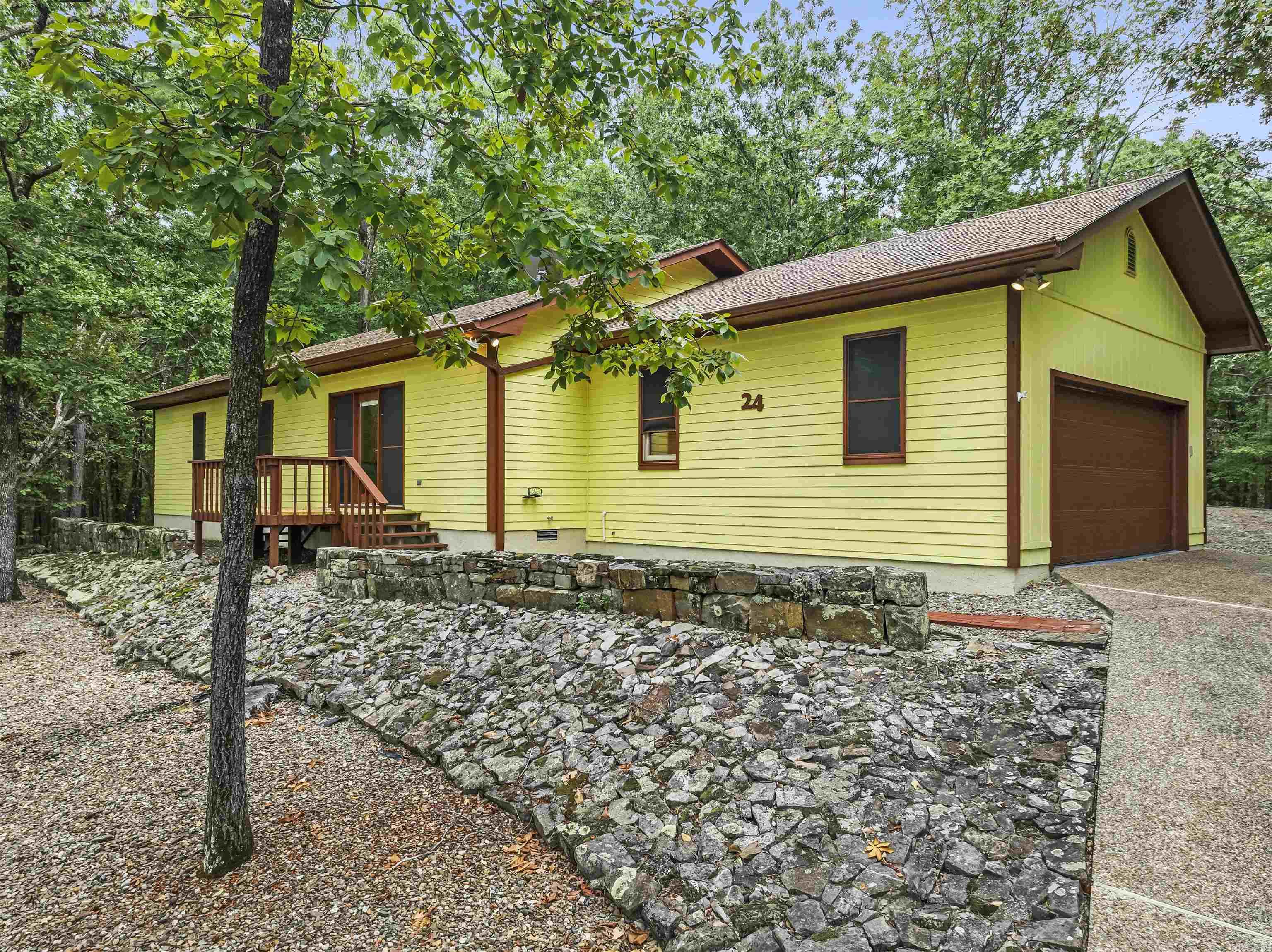 Discover the charm of this delightful home at 24 Cadiz Lane in Hot Springs Village. With a stunning view from the front porch, you can start your mornings with a cup of coffee and enjoy the beauty of the surrounding landscape. This cozy home offers an open floor plan, perfect for entertaining. The living, dining, and kitchen areas flow seamlessly together, featuring a vaulted ceiling that creates a spacious feel. Kitchen has newer appliances. The home includes two bedrooms and two bathrooms, providing a comfortable and functional living space. Outside, you'll find a private back patio ideal for relaxing or grilling. The property also features a small fenced area, perfect for your small furry friends, a two-car garage, and a covered area for extra parking or storage. Recent upgrades, including a newly painted exterior and a new roof, mean you can move in with peace of mind. New Member Buy-in Fee due at closing.
