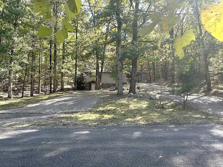 Nestled in the gated Diamondhead South community, this spacious home offers a flexible layout and unique outdoor features. Enter through the carport into a kitchen that opens to the living room, complete with sliding glass doors leading to a large deck. Two bedrooms and a full guest bathroom are located to the left of the living area—one bedroom also provides direct deck access. The kitchen includes a generous pantry wall and a laundry closet for added convenience. A winding staircase at the back of the living room leads to a second living area, a second full bathroom, the third bedroom, crawl space access, and a door to the front yard. Outside, enjoy a peaceful backyard with a small pond, a charming bridge, and a firepit area—perfect for relaxing or entertaining. This property is priced to sell and offers plenty of potential for buyers ready to bring their vision to life. With its location, layout, and outdoor charm, it may attract multiple offers. Don’t miss your chance to explore the possibilities!