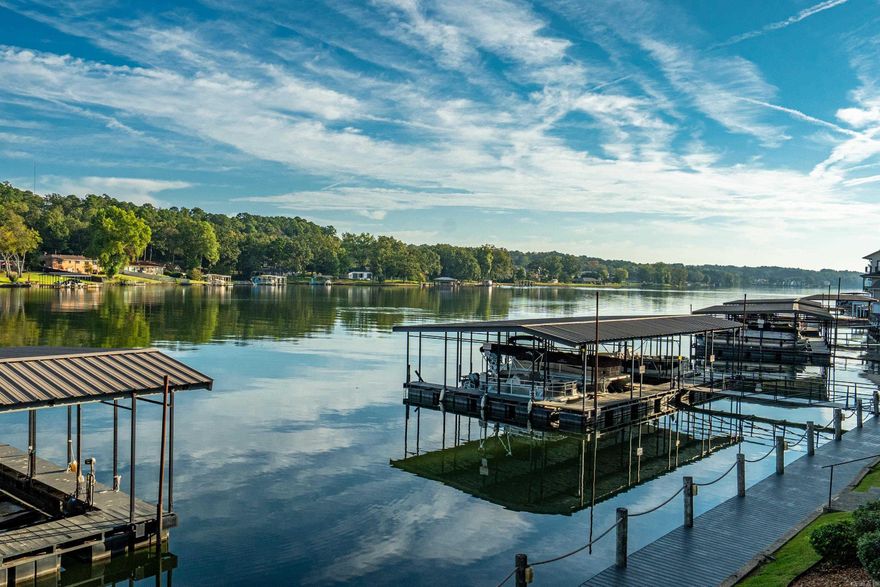 Walk-in level lakefront 2 bedroom/2 bath condo with beautiful views of Lake Hamilton complete with a covered boat slip with a lift and an attached one car garage. Beautiful high end laminate flooring just installed.  This spacious condo is located in a gated complex that is fully fenced with a pool, hot tub, club house and a large green area to walk your furry friends.  Convenient location to area restaurants, shopping and entertainment.  NO NIGHTLY RENTALS ALLOWED.