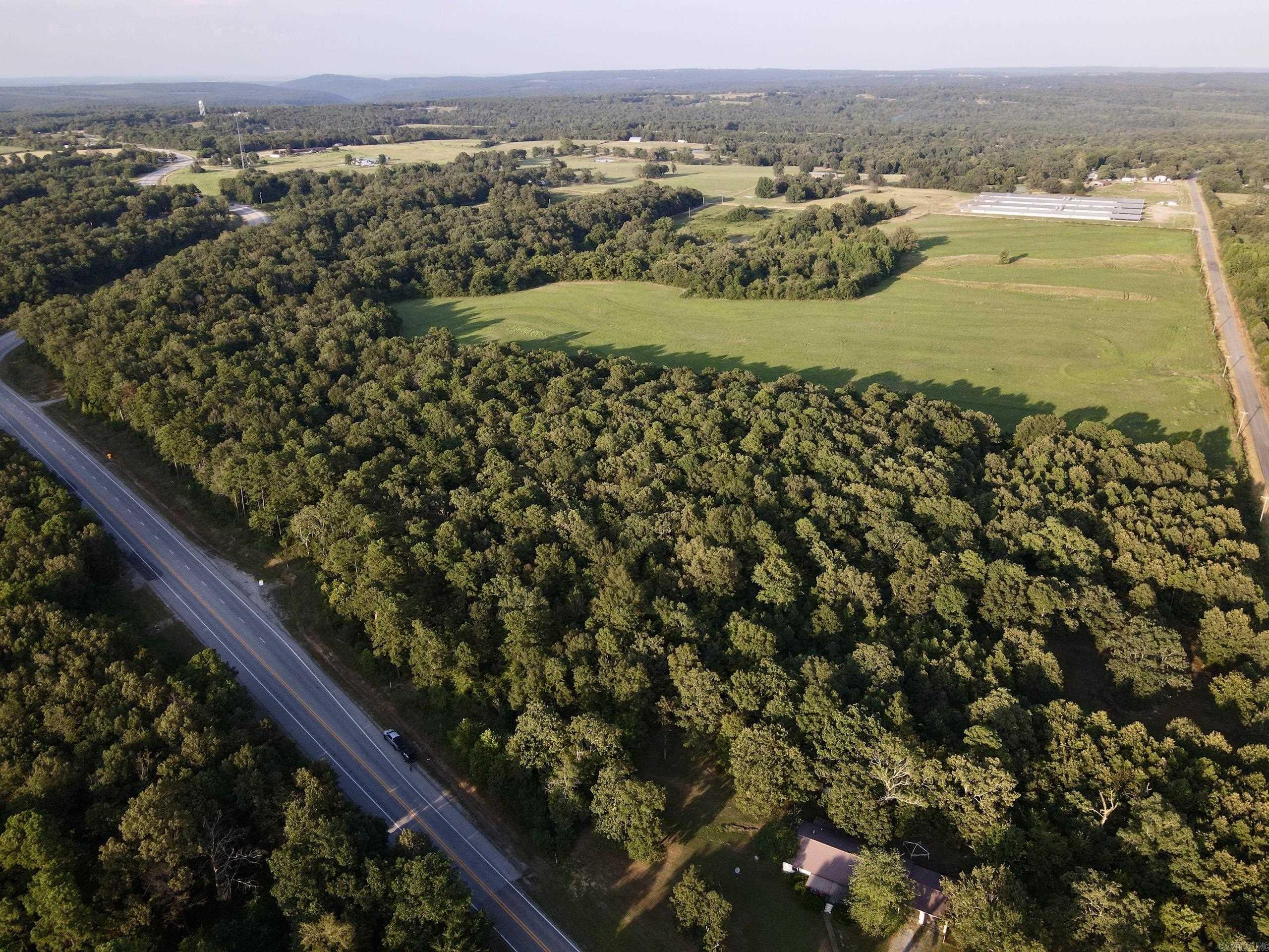 A rare and versatile land offering with approximately 4,000 feet of road frontage across three sides, this exceptional property presents boundless opportunities for builders, investors, and those seeking the peace and potential of rural living. Conveniently located near the sparkling waters of Greers Ferry Lake and the renowned Little Red River, this tract combines natural beauty with practical features. The land is fully fenced and suitable for livestock or agricultural use.
