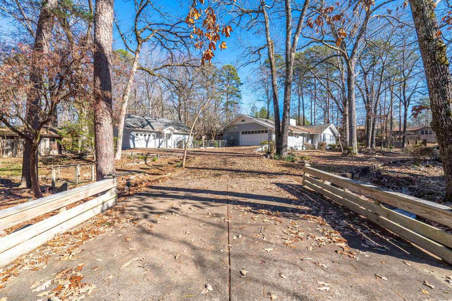 Motivated Seller! Main House 3 bedrooms and 3 full bathrooms.  Small House has a guest quarters with one bedroom and one bathroom. Welcome to your dream retreat a charming neighborhood! Discover the timeless elegance of this classic home, set on an expansive 1.67-acre property that invites exploration and serenity. Just a short drive to Lakes Hamilton, Ouachita, and Catherine as well as Oaklawn Racing Casino for all your weekend adventures. The quintessential fireplace becomes the focal point for cozy evenings, providing the perfect backdrop for making cherished memories. A hidden gem on the property is the spacious studio guest house, complete with its own bathroom and new stackable washer/ dryer, offering endless possibilities for customization to suit your unique needs.  Stroll through the lush surroundings, where walkways and charming bridges connect you to the seclusion of nature, all within the secure embrace of a close-knit community. Recent updates include: Fresh paint throughout on walls, ceilings, and cabinets, new flooring, new toilets and faucets, floor air vents, new microwave, new water heater, and landscaping. Sq footage approx, pls measure.