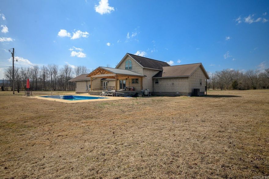 Experience PEACEFUL COUNTRY LIVING on 12.72 ACRES m/l just minutes from SOUTHSIDE SCHOOLS. This well-built 3,196 SQ FT home, constructed in 2008 by DEWAYNE HOOKER, features 3 BEDROOMS, 2.5 BATHS, and MULTIPLE BONUS AREAS designed for flexibility. The OPEN-CONCEPT interior is highlighted by TALL CEILINGS, LARGE WINDOWS, and abundant NATURAL LIGHT. An UPDATED KITCHEN offers GRANITE COUNTERTOPS, STAINLESS STEEL APPLIANCES, and CUSTOM CABINETRY, perfect for ENTERTAINING. The MAIN BEDROOM includes a convenient WALK-IN TILED SHOWER. Designed with accessibility in mind, the ENCLOSED GARAGE has been converted into a HANDICAP-ACCESSIBLE BONUS ROOM, and the HALF BATH is also HANDICAP ACCESSIBLE. A versatile LOFT AREA provides the perfect space for an OFFICE, PLAYROOM, or GUEST QUARTERS. Outdoor amenities are equally impressive, featuring a NEWER DECK AND PORCH overlooking the SCENIC ACREAGE and POND. Enjoy the 16x32 IN-GROUND POOL and a recently added PATIO with a CONCRETE SLAB and PAVILION, creating the ultimate POOLSIDE HANGOUT. This property perfectly balances SPACE, ACCESSIBILITY, and ACREAGE while remaining close to town conveniences. A true MUST-SEE for those seeking room to breathe!
