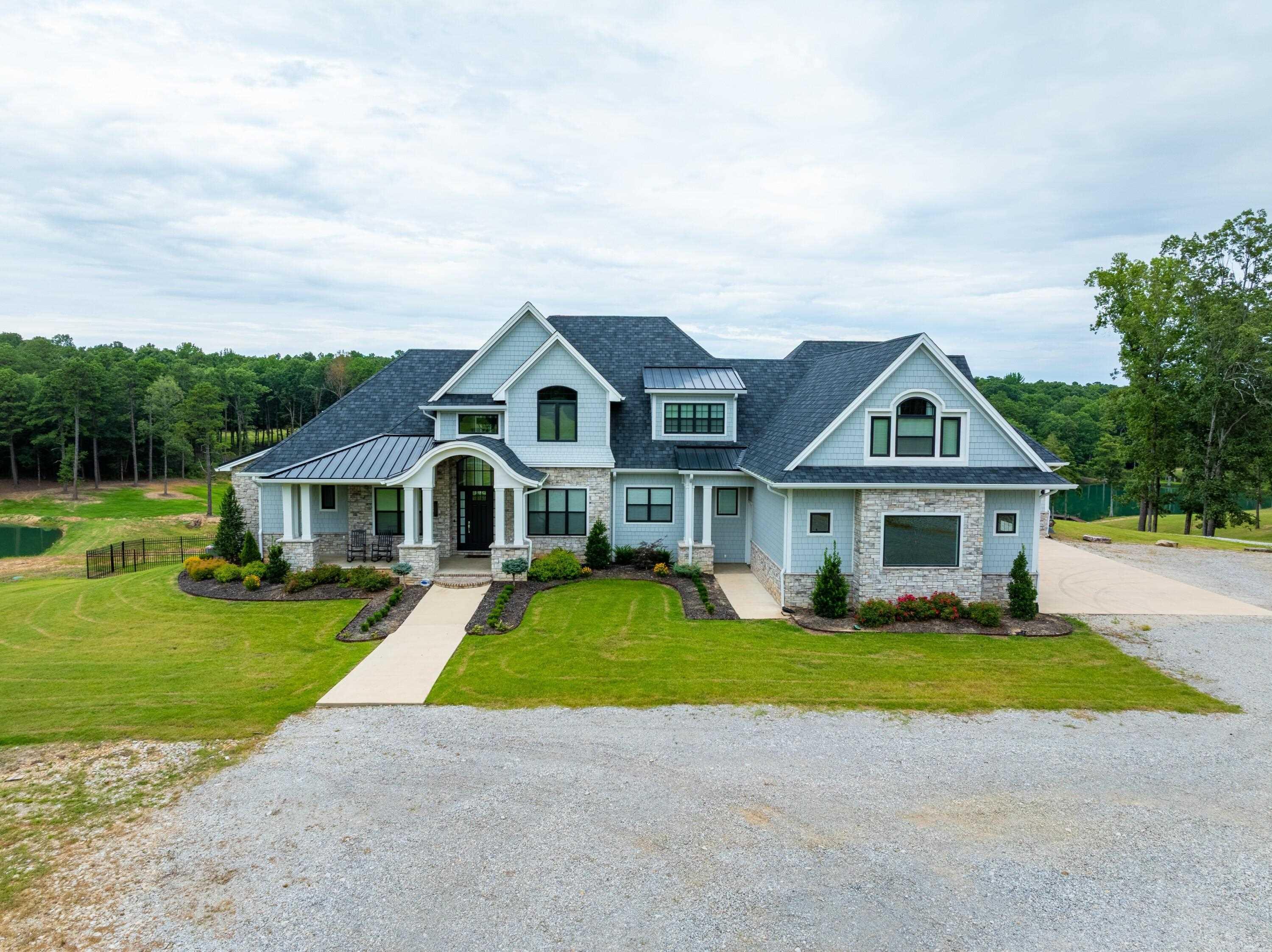 Incredible luxury estate just outside Paragould city limits on approx. 36± acres! This custom-built home offers over 12,000± sq ft under roof, with approx. 9,600± heated/cooled living space. Featuring 6 bedrooms, 6 baths, 2 half baths, and a dream layout across 3 levels. Main floor includes a chef’s kitchen w/ commercial appliances, walk-in pantry, formal dining, office, large living room w/ gas fireplace, and a primary suite w/ spa-style bath and private balcony. Upstairs offers 3 bedrooms, 2 baths, sitting area, and reading nook. Walk-out basement includes 2 beds, 2 baths, kitchenette, theater room, safe room, and full access to the indoor, heated/cooled multi-sport court and gym. Outside features a private gated drive, koi pond, in-ground pool, hot tub, putting green, and multiple covered patios/balconies. Includes 3-car garage plus a pull-through garage with attic space ready to finish. Incredible wildlife, woods, lakes, and room to hunt or relax—all minutes from town. Furniture negotiable. Additional acreage available.