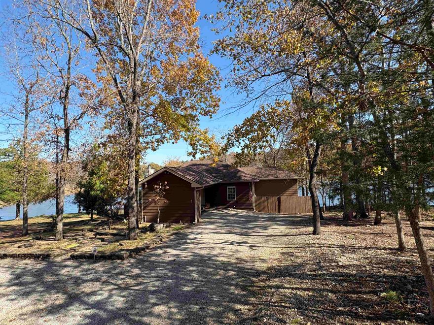 Wake up every day on Lake Cherokee, perched right above the waterfall at Papoose Park, where the sound of rushing water and wide-open lake views become part of your routine. This well built 3BR/2BA, 1472sqft home lives large with 9’ ceilings and windows that bring the constant lake views with lakefront access. Inside, the kitchen features granite countertops, a center island, and views straight across the water. The living space blends retro charm with modern comfort, centered around a cozy gas fireplace. The primary suite is its own retreat with a full sitting area and panoramic lake views. Step outside onto the vaulted, covered deck or wander down the landscaped paths to the covered dock—your front-row seat to sunrise coffee, evening fishing, or quiet moments on the water. The fenced yard, wraparound decks, covered carport, and workshop underneath the home make lake living easy. Carport also includes that extra storage room everyone needs for their lake life supplies. This isn’t just a home—it’s a lifestyle at the water’s edge.