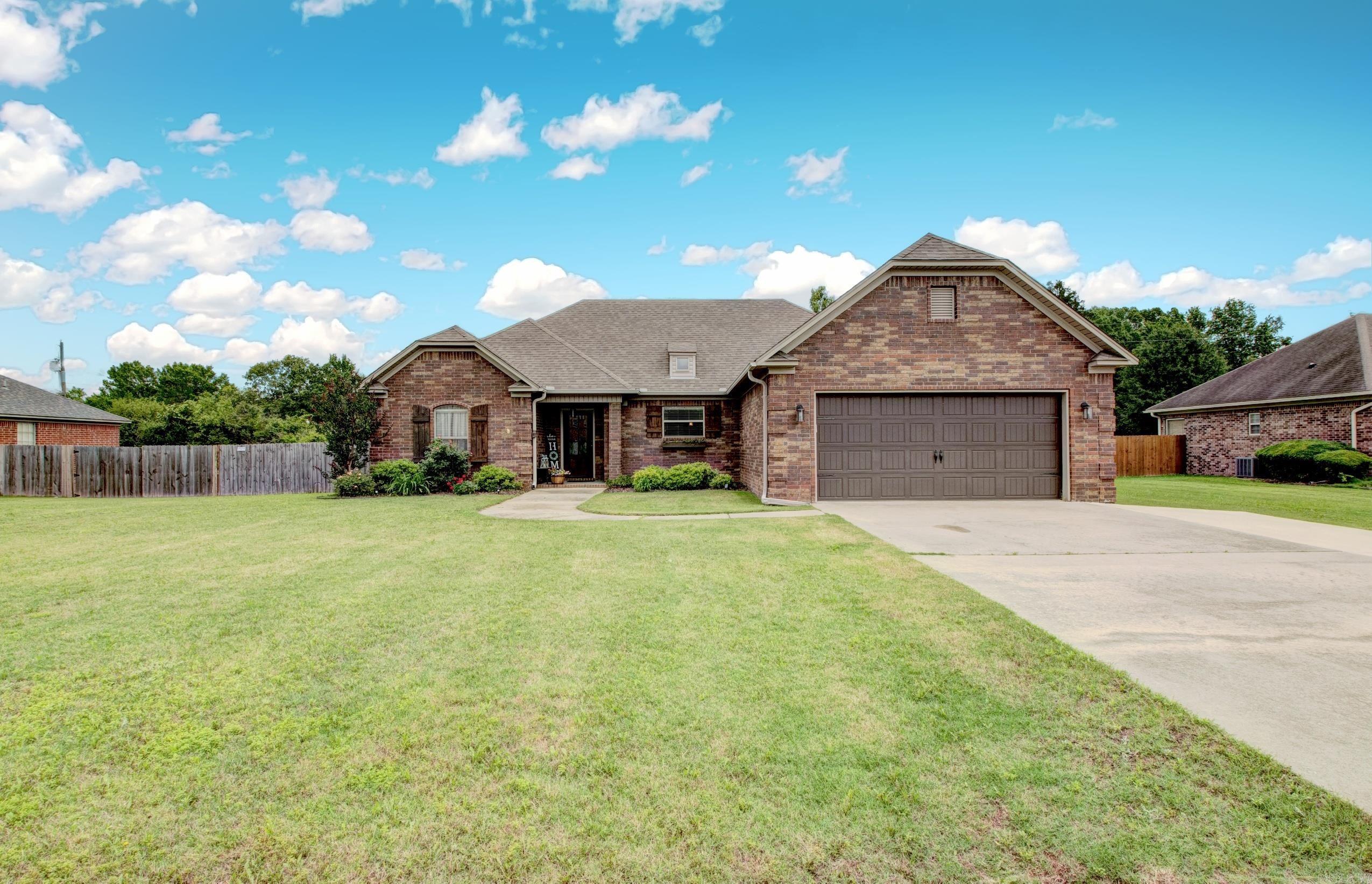 Lovely traditional situated on a 1/3 of an acre lot! Open floor plan with a cozy wood burning fireplace with gas logs! Kitchen features breakfast bar, stainless steel appliances, lots of cabinetry, walk in pantry and granite countertops. Lovely stained concrete floors with carpet in the two guest bedrooms. Primary bedroom apart with a nice large primary bath with separate walk in shower and jetted tub. Great storage space throughout and relax on your partially covered deck with an amazing level fully fenced large backyard! Shed conveys.