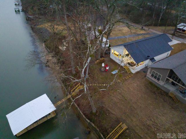 Nestled in the heart of Hot Springs, this cozy cabin offers the perfect lakeside retreat. With 3 spacious bedrooms and 2 1/2 baths, it comfortably sleeps 10 guests, making it an ideal getaway or a turnkey investment property. Located in the highly sought-after Lakeside School District, this home is just 10 minutes from downtown Hot Springs, Oaklawn Racing & Casino, and minutes from the picturesque Garvan Woodland Gardens. The open floor plan is perfect for entertaining, with a seamless flow between living, dining, and kitchen areas. Step outside to enjoy the expansive outdoor living space, complete with a 70-inch TV on the back patio, a firepit, and your very own boat slipāperfect for relaxing and enjoying the stunning lakeside views. Whether you're searching for a serene home or a high-demand rental property, this cabin has everything you need to enjoy the best of Hot Springs living. This home comes completely furnished, all you need is your toothbrush. :)