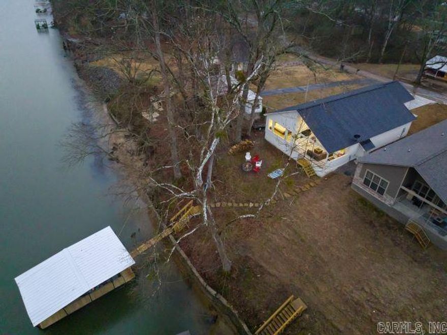 Nestled in the heart of Hot Springs, this cozy cabin offers the perfect lakeside retreat. With 3 spacious bedrooms and 2 1/2 baths, it comfortably sleeps 10 guests, making it an ideal getaway or a turnkey investment property. Located in the highly sought-after Lakeside School District, this home is just 10 minutes from downtown Hot Springs, Oaklawn Racing & Casino, and minutes from the picturesque Garvan Woodland Gardens. The open floor plan is perfect for entertaining, with a seamless flow between living, dining, and kitchen areas. Step outside to enjoy the expansive outdoor living space, complete with a 70-inch TV on the back patio, a firepit, and your very own boat slip—perfect for relaxing and enjoying the stunning lakeside views. Whether you're searching for a serene home or a high-demand rental property, this cabin has everything you need to enjoy the best of Hot Springs living. This home comes completely furnished, all you need is your toothbrush. :)