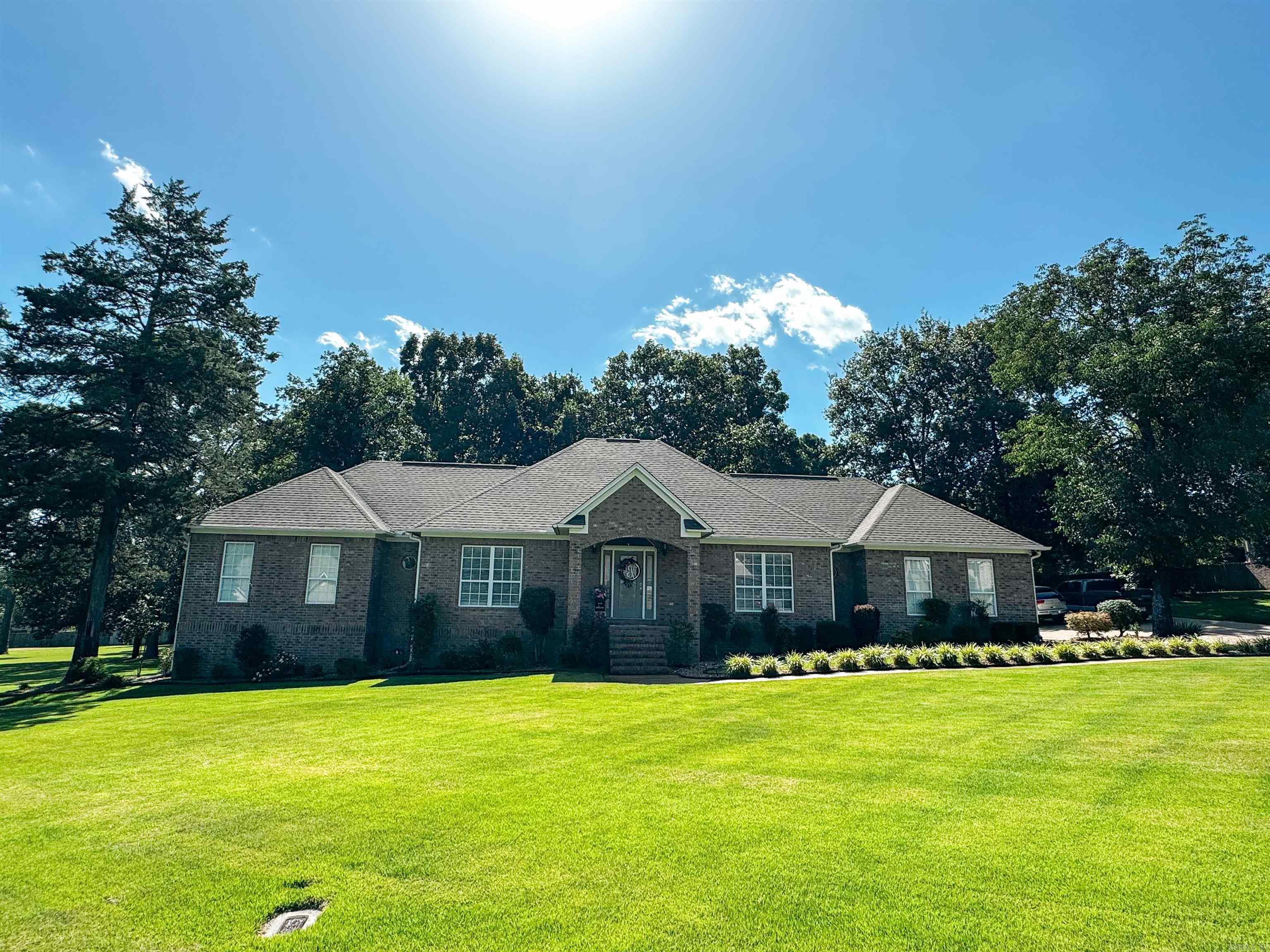 Gorgeous home in a desirable neighborhood on a beautiful lot with mature oak trees and plenty of space to spread out! Walk into this home and you will find a large open dining room & spacious foyer that leads to a lovely living area with a gas log fireplace, crown molding throughout, tray ceilings, ample closet space & more. The slate tile in the kitchen & breakfast area has been updated with hardwood floors in the dining, living room, foyer & down the hallway. Kitchen and baths have granite countertops. The primary bedroom is so roomy with access to the back deck and has plenty of space for a sitting area, desk, or extra furniture. The closet is divided into his & her spaces separated by shelving for privacy & the bathroom has a separate lavoratory closet, two sinks, jacuzzi style tub & a walk-in closet. There is an over-sized deck AND a covered back patio off the breakfast room! Don't forget the storm shelter in the garage that doubles as a storage closet. The garage is large enough for two cars AND golf cart & mower storage on the side! Agents see remarks for other details!