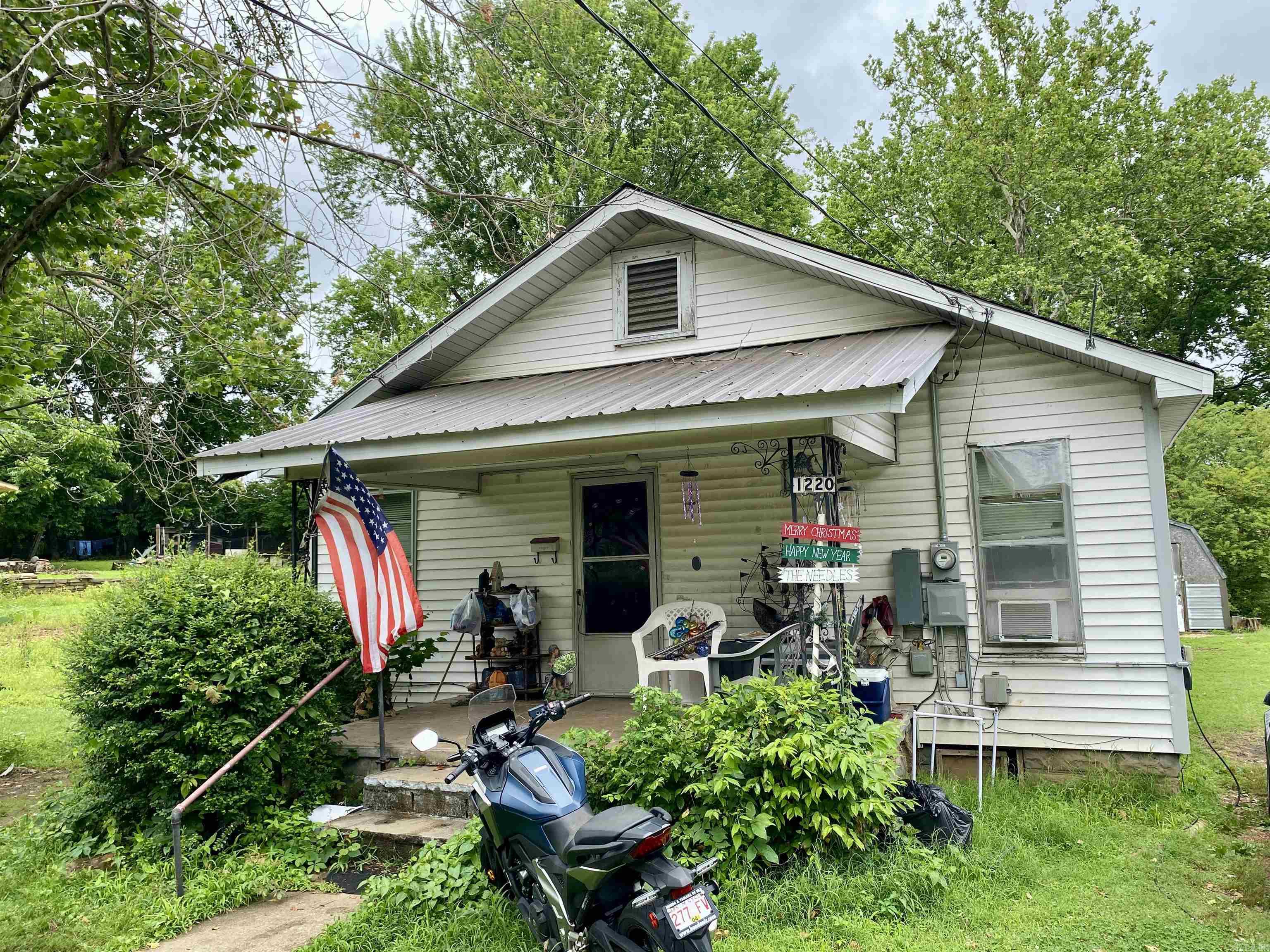 Affordable 2BR/1BA investment opportunity located in town near Clarksville Schools and the Multi-Purpose Building. This solidly built home offers great potential with minor updates needed to make it shine. Features include a charming front covered porch, an eat-in kitchen with original cupboards, gas range, and refrigerator. Two gas wall heaters, two window units, and a portable air unit will convey. Half of the roof has been updated with durable metal roofing. Whether you're looking for a rental property or budget-friendly housing, this home is a smart buy with strong potential.