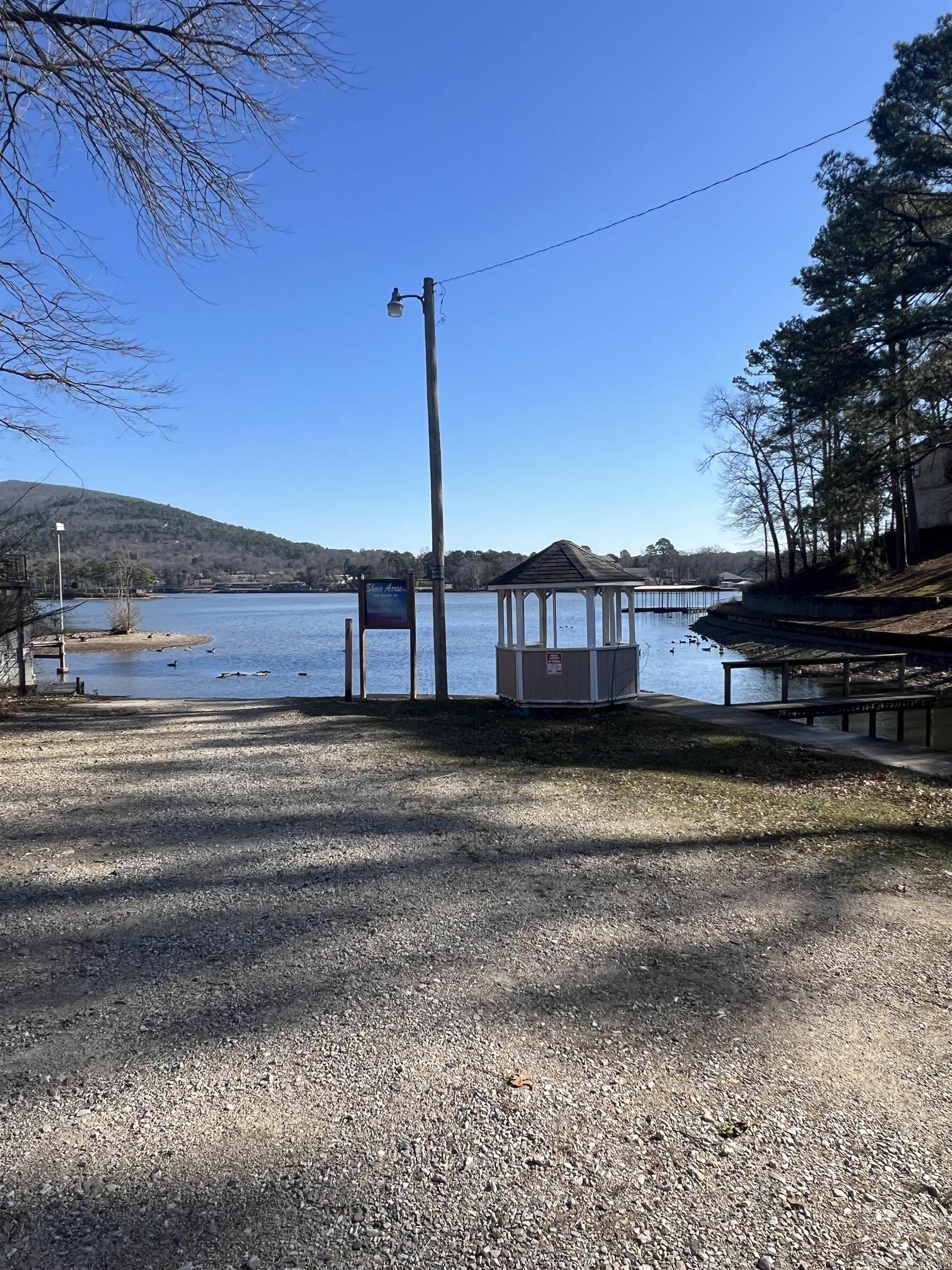 Great vacation home or nightly rental. This 2 bedroom 1 bath mobile home is located outside the city limits. Built in 2016, this cute, clean home won't be on the market long. Also included are a two car metal carport and storage shed. Conveying with home are 9 lake lots with 5 piers and one gazebo. All located in Shore Acres Boat Club. Each lot is roughly 10'x20'. Boat ramp is part of Shore Acres and is used by all members.($40 annual fee for boat ramp). Plat for lake lots is located in the pictures (lots are highlighted in yellow). New roof in 2025