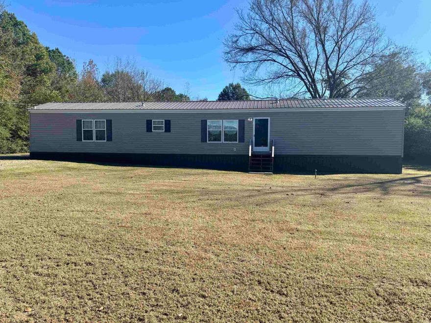 3BR/2BA Manufactured home on 1 acre. This home has been completely renovated with a new roof, underpinning, new hvac, flooring, kitchen sink, kitchen cabinets, granite countertops, bathroom vanities, ceiling fans, light fixtures, new paint, appliances, hot water heater, electric outlets, toilets, front and back porches, & a gravel driveway. There is an outbuilding with new floors and a window unit that can be used as a man cave or extra storage. The septic system has been pumped & cleaned.  The master bath has a new walk-in shower with a large walk-in closet.  The second bath has a shower/tub combo.  Nice built in shelving in the living room.  Great location! Space to let the kids and animals run around.