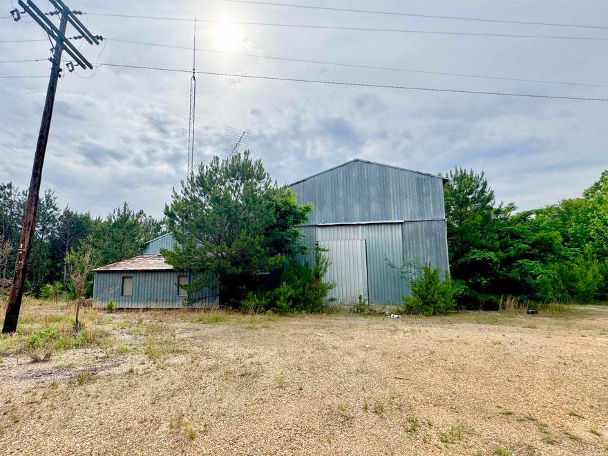 Located on ideal highway frontage, this unique property offers versatile interior and exterior space! Over 10,000 sq ft of slab workshop sits on 17+ acres with gravel perimeter and three large shop doors.  While this property will need a fresh start and some TLC, the location and amenities are hard to find. Seller will give priority to a buyer that will move forward with a as-is sale. Clean title awaits the new owner!
