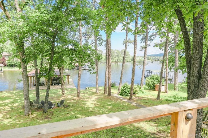 Nestled along the serene shores of Lake Hamilton, this exquisite 5 bedroom, 4 bath home epitomizes luxury living at its finest. Recently renovated with meticulous attention to detail and boasting high-end finishes throughout, this residence is a testament to modern elegance and comfort. Spanning across a generous acre lot, this expansive home offers ample space for both relaxation and entertainment. With 5 bedrooms and 4 baths, including two primary en suites, there's plenty of room to accommodate family and guests comfortably. The heart of this home is its gourmet kitchen, equipped with top-of-the-line appliances, custom cabinetry, and expansive granite countertops. Prepare to be captivated by breathtaking vistas of Lake Hamilton from nearly every room in the house. Floor-to-ceiling windows invite natural light to flood the interiors, creating a seamless connection between indoor and outdoor living spaces. Step outside to discover your own private paradise, where lush landscaping and panoramic lake views set the stage for outdoor enjoyment. Lounge on the expansive deck, soak up the sun on the sprawling lawn, or embark on aquatic adventures from your brand new two-stall boat dock.