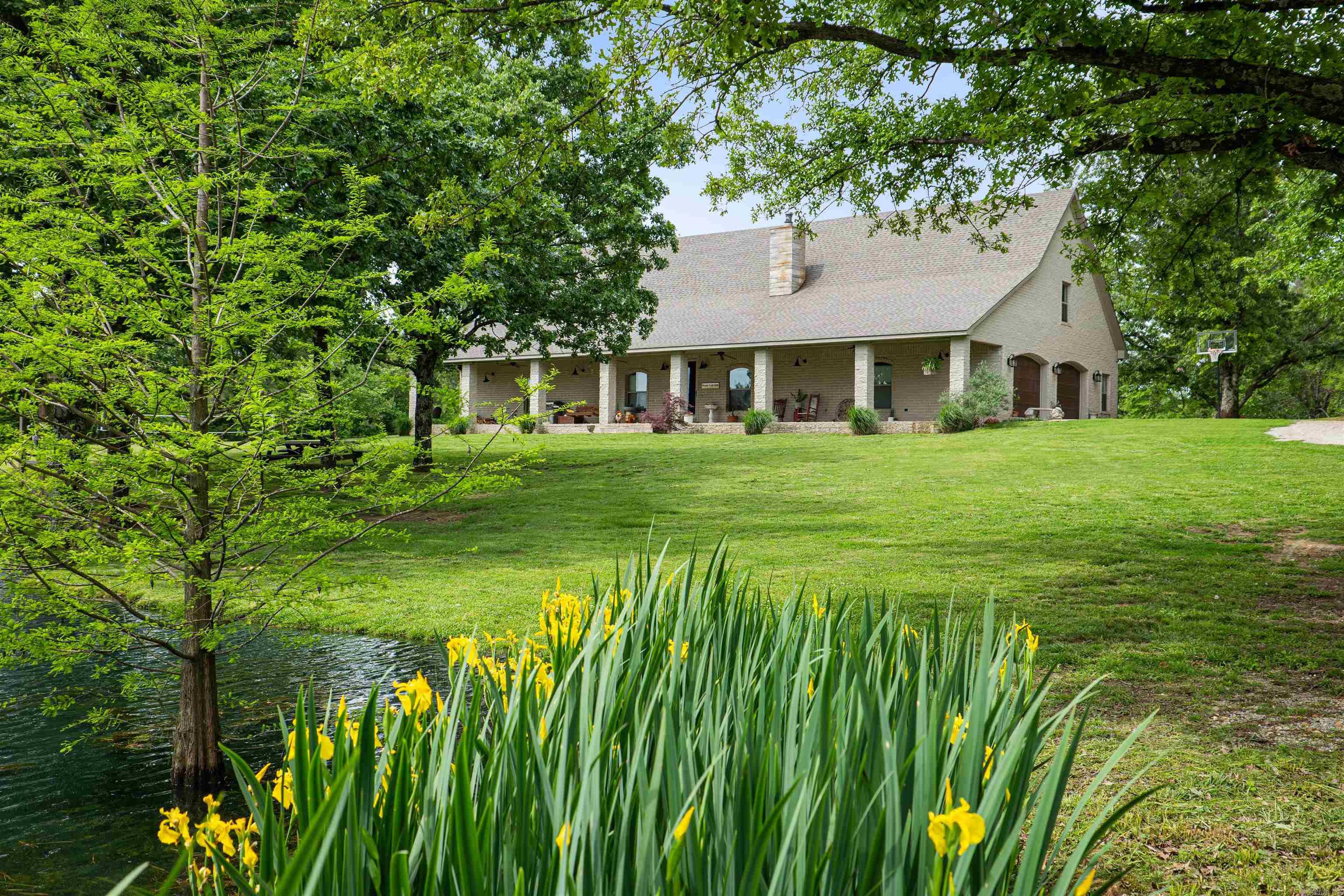 Welcome to your dream country retreat! This custom-built home is nestled on 2.5+/- acres at the end of a long driveway, offering unparalleled privacy and tranquility. The property features a serene pond, perfect for fishing or simply enjoying the peaceful surroundings. The expansive porch invites you to relax and take in the scenic views and watch the ducks. Step inside to an open floor plan adorned with beautiful tile and wood floors, creating a warm and inviting atmosphere. Natural light floods the home, highlighting the stunning vistas visible from every room. The sunroom is a true gem, providing a perfect space to unwind and enjoy the beauty of nature year-round.The primary bedroom is a sanctuary of comfort, offering breathtaking views and ample space. The en-suite bathroom is a spa-like haven, featuring a luxurious clawfoot tub as its centerpiece, an impressive walk-in shower, and abundant closet space to accommodate all your storage needs.Additional amenities include a spacious garage, a safe room for peace of mind, and so much more. This property is not just a home; it's a lifestyle—a perfect blend of comfort, luxury, and country charm.Don't miss this opportunity.
