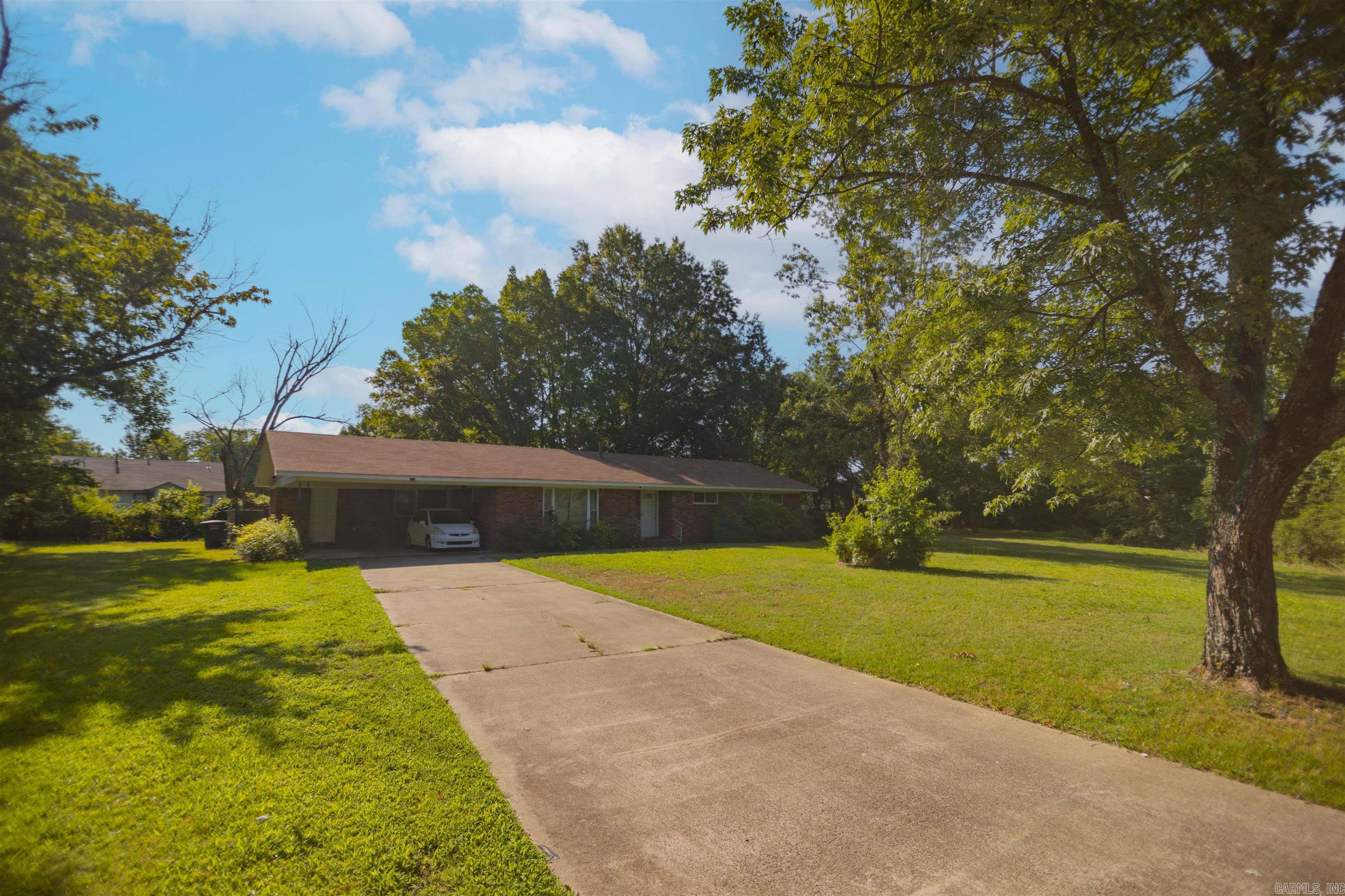 Extensively remodeled home nestled on almost an acre of privacy in the middle of town! Updates include tile flooring throughout living areas & baths, interior paint, newer vinyl windows, light fixtures, & remodeled kitchen with custom cabinets, granite countertops, & matching SS appliances. Low maintenance brick home on a slab with new roof in 2019. Agents See Remarks.