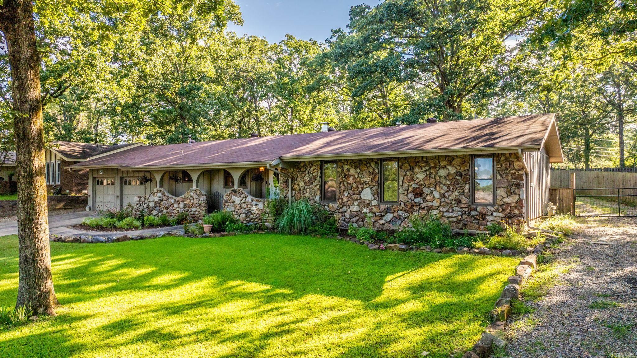 Stunning home directly across from Indian Head Lake with lake access! Charming curb appeal with rock-lined landscaping, cedar and rock exterior, custom arched entry with iron gate, and extra drive-through driveway leading to a 20āx40ā shop with electricity & water. Inside offers 3 bedrooms, 2 baths, and a versatile master suite with attached sitting room or nursery. Enjoy a cozy den with rock fireplace, driftwood accent wall, and access to a custom 22āx18ā covered deck overlooking a beautifully landscaped, fully fenced backyard. Kitchen boasts custom soft-close cabinetry, butcher block island, and Frigidaire Gallery stainless appliances. Additional features include a 4āx4ā FEMA storm shelter, garden area, outdoor sink, and major updates including newer windows across front, custom cabinets, and HVAC servicing. A rare gem with both comfort and convenience near the lake!