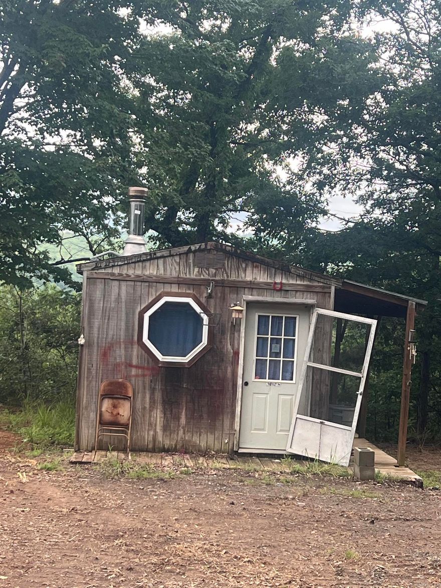 Rural tract of land on well maintained county road with beautiful views.  Electricity and water meter on property and fiber internet available.  No restrictions.  RV's and Mobile Homes allowed.  Partially finished tiny home conveys with the land.