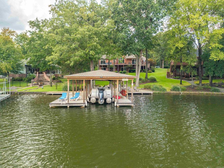 Offering the Best of Lakeside Living in Stonegate Shores Subdivision! This stunning 6-bedroom, 4-bathroom home is the perfect blend of luxury, comfort, & functionality! Step inside to discover a thoughtfully designed floor plan w/ large windows throughout filling the home w/ natural light & providing picturesque views of Lake Hamilton. The beautiful kitchen features high-end appliances, ample cabinetry, quartz countertops, a breakfast bar + eat-in breakfast area. The open layout flows seamlessly into the hearth room & dining area! The primary suite features a luxurious ensuite bathroom. There are 2 additional bedrooms on the main level, a full bathroom & fantastic laundry room! The lower level features 3 additional bedrooms, 2 full bathrooms, a 3rd living area + a game room!  Whether you’re enjoying quiet time in the upper living space, cozy evenings by the fireplace in the hearth room, or family fun in the basement-level living space, this home was designed w/ versatility in mind. Step outside and take in the view from one of the numerous outdoor sitting areas, the lakeside patio, stationary boat dock & swim dock! Great location by land & water! Call today for a private tour!