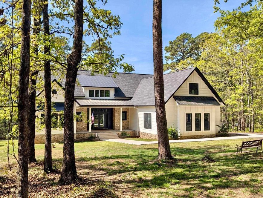 This beautifully designed home on Greers Ferry Lake offers wooded privacy and an easy walk to the shoreline, newly built in 2022. Enjoy stunning sunsets and Heber Springs’ annual fireworks from the privacy of your own property. This 2,553 sq ft home features 3 bedrooms and 2.5 baths on the main level, plus a bonus room that can serve as a game room or 4th bedroom upstairs. The bright foyer opens to a living, dining, and kitchen area with an open layout ideal for entertaining. The kitchen includes smart black stainless appliances, leathered granite countertops, gas cooktop stove with pot filler and a large island with seating for four. All bedrooms offer spacious walk-in closets, and the primary en-suite features a soaking tub, walk-in shower, and a large closet that connects to the laundry room. A covered back porch provides a perfect outdoor space to relax or grill and entertain with a view. Outdoor accent lighting enhances the home’s exterior, paired with a spacious two-car garage. This community offers a private airstrip, boat ramp, and Tannenbaum Golf Course which are just minutes away. Check out this listing, it has all of the extras!