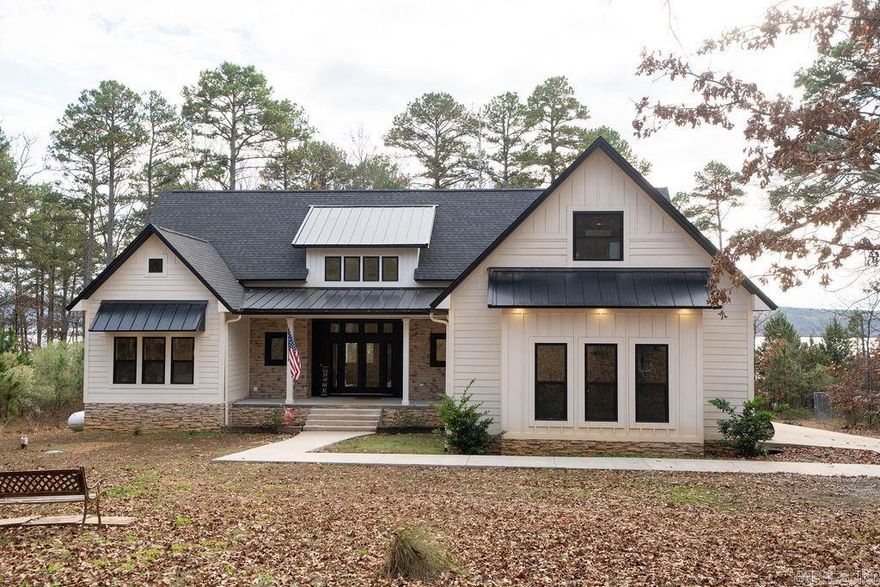 Welcome to the market this beautifully designed, newly built 2022 home on Greers Ferry Lake, offering wooded privacy and an easy walk to the shoreline. Enjoy stunning sunsets and Heber Springs’ annual fireworks from the privacy of your own property. This 2,553 sq ft home features 3 bedrooms and 2.5 baths on the main level, plus a bonus room that can serve as a game room or 4th bedroom upstairs. The bright foyer opens to a living, dining, and kitchen area with an open layout ideal for entertaining. The kitchen includes smart black stainless appliances, leathered granite countertops, gas cooktop stove with pot filler and a large island with seating for four. All bedrooms offer spacious walk-in closets, and the primary en-suite features a soaking tub, walk-in shower, and a large closet that connects to the laundry room. A covered back porch provides a perfect outdoor space to relax or grill and entertain with a view. Outdoor accent lighting enhances the home’s exterior, paired with a spacious two-car garage. This community offers a private airstrip, boat ramp, and Tannenbaum Golf Course which are just minutes away. Check out this listing, you don't want to miss it!