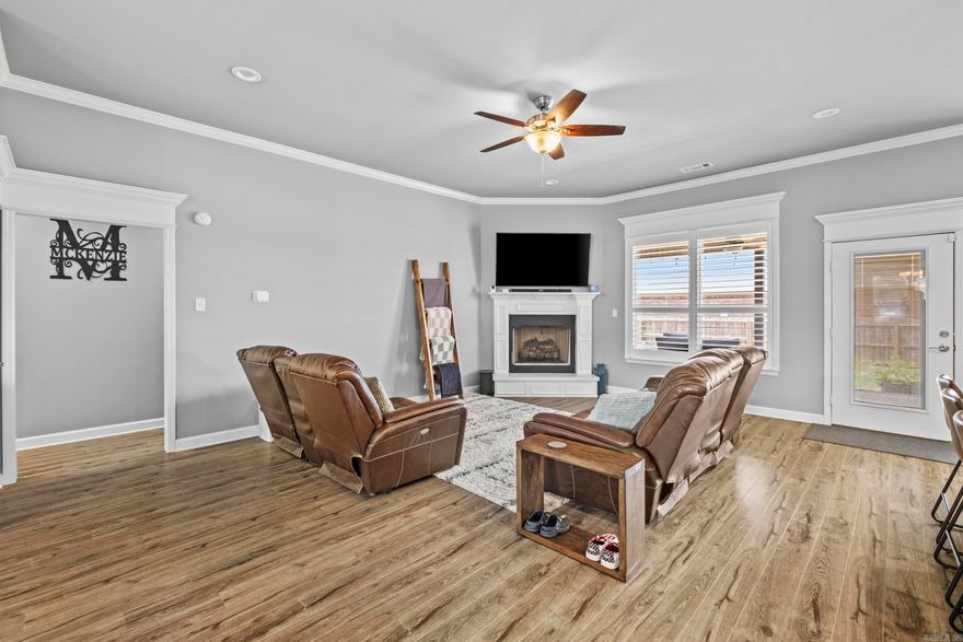 This Immaculate 4-bedroom, 2-bath home showcases a contemporary open floor plan, featuring a large kitchen island and an expansive living room with a cozy fireplace. The main suite boasts an oversized custom shower, a spacious walk-in closet, and double vanities in the en-suite bathroom. Elegant plantation shutters adorn the windows, and the property's corner lot location offers a side load garage for added convenience. Step outside to a covered back porch, making it the perfect spot for outdoor relaxation and entertaining.