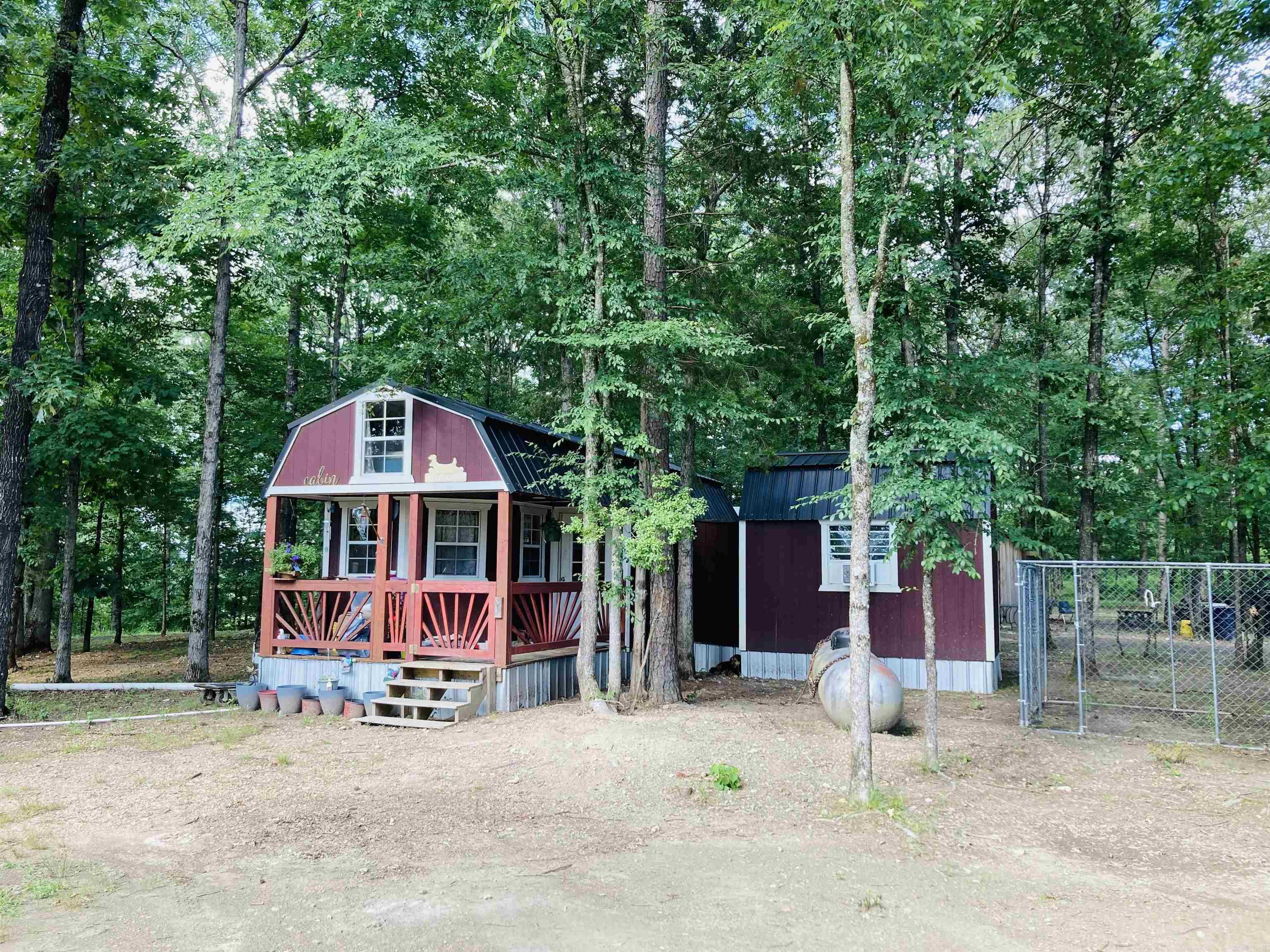 Were Buggin' OUT! Let's go to the COMPOUND! Perched high on a hill on 40 acres, with beautiful 360 views is the Cozy Cabin, 2nd cabin AND 3rd cabin and multiple outbuildings. The red cabin, has an addition with one bedroom, a spacious bathroom/washroom, four lofts, propane heat, and a 200 ft well. The green cabin (288 sq ft) features double lofts, propane heating, electricity, and a frost free water hydrant next to the porch. Additionally, the third cabin also has electricity. The 480 sq ft outbuilding with electricity and a lean-to for a mower is ideal for gatherings and cooking outside. Ride your ATV to the National Forrest from this location!! Bring all the relatives!! Two 30-amp RV plugs, a circle drive, fencing on three sides, and a shale pit convenient for road maintenance. Located 1.5 miles from the Mountain Fork River, and 2 miles from the Oklahoma line, this property is perfect for a business venture like an RV park or the perfect quiet place to get away. Buyers have the option to purchase either a square 40-acre block or 40 irregular acres (see photo). Don't miss out on this one-of-a-kind opportunity with stunning views and endless possibilities!