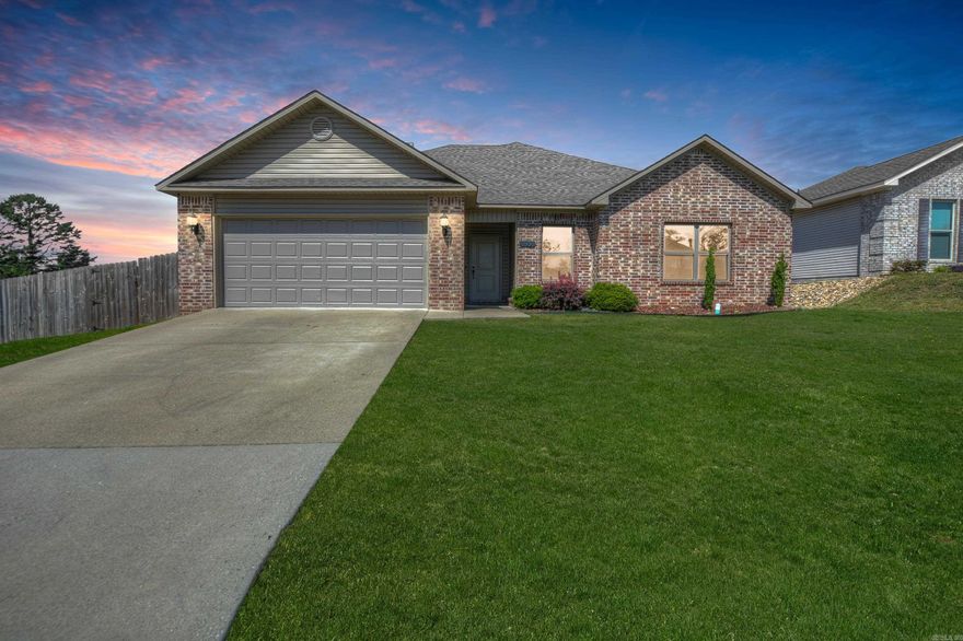 Welcome to 199 Hillshire Loop—where comfort, location, and lifestyle meet! This well-maintained 3-bedroom, 2-bath home offers 1,633 square feet of thoughtfully designed living space in the sought-after Hamilton Park neighborhood. Built in 2017, this home sits on a scenic corner lot, perfectly positioned on the hillside with partial views of Lake Hamilton—arguably one of the best spots in the community! Step inside to a spacious, open-concept layout featuring a wood-burning fireplace in the family room and a bright kitchen with breakfast nook, walk-in pantry, and plenty of counter space. The primary suite is a true retreat, offering double walk-in closets, a jetted tub, walk-in shower, and dual-sink vanity. Enjoy outdoor living on the covered patio, overlooking a large, fully fenced backyard—ideal for kids, pets, or entertaining. The exterior boasts brick accents on the front, low-maintenance vinyl siding, and an attached two-car garage. Located in the Lake Hamilton School District and surrounded by a family-friendly community, this home blends everyday convenience with the charm of lakeside living.