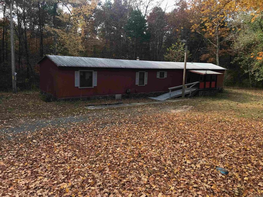 GREAT STARTER HOME and priced for a quick sale.  76' x 16' Manufactured home title has recently been legally cancelled as a mobile home, AND now an Affidavit of Affixation has been recorded.  It will be conveyed as a home with land.  The  3BR/2Ba, has open living/dining/kitchen.  Range is gas, as is the heating system.  Also a gas wall heater in one BR.  Flooring is laminate, carpet, & vinyl.  Kitchen appliances and the washer/dryer will convey with sale.  Metal roof, and permanent foundation.  The front entry has a ramp and covered porch for handicap accessibility.  The back deck is approx. 330 sq.ft. and partially covered.  If you need extra storage space, there is a 30x12' detached carport with storage room, PLUS another12x8' storage building.  All on just under an acre.  Location is between Fairfield Bay and Shirley on Hwy 16.  Selling AS IS.  Call us to take a look! Agent Remarks.