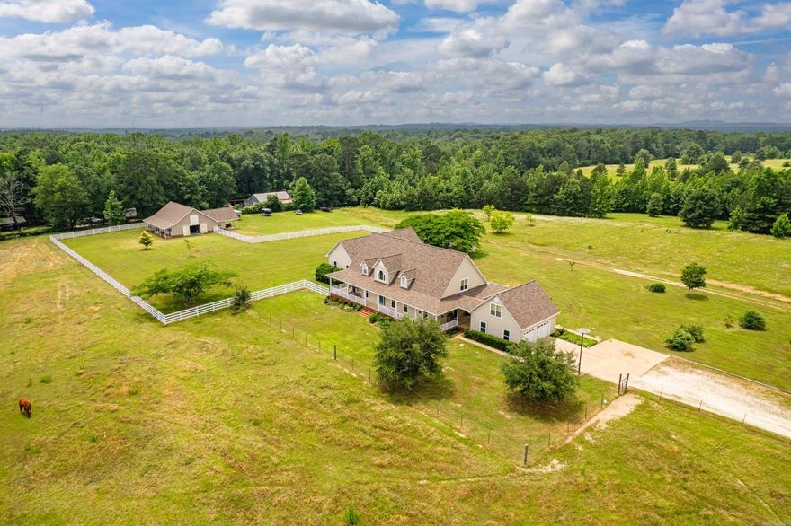40 acres + 2 barns + hay loft + stalls + cross fenced + 2 ponds +  in-law suite + sunroom +  500SF loft apt + wrap around porch and so much more!!! Experience serene country living on 40+ acres with space to stretch—indoors and out! This 4,500 sqft estate features expansive living areas, a large kitchen, formal dining room, abundant storage throughout, and oversized bedrooms with generous closets. Bonus: a separate 500 sqft private loft apartment, perfect for guests, in-laws, or older children.   Home and barn have had a new roof, new gutters & siding installed. Home is on a ground source heat pump system which ensures your utility costs are kept to a minimum. All appliances convey.