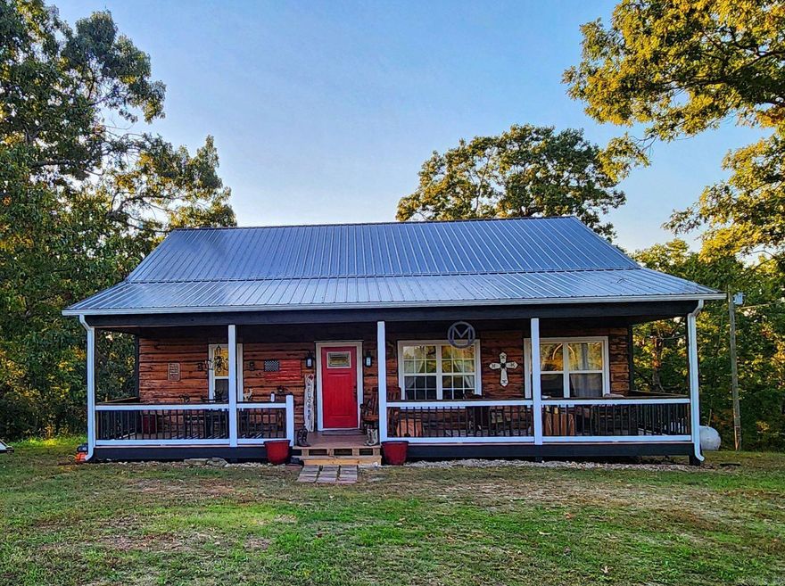 Gorgeous! This unique custom-built cabin is located in the Ozarks just minutes from the Natl. Forest, White River, & world-renowned Mtn. View! Nestled on over 10 serene ac of woodland with pasture area, the 10X40' front porch/outdoor living space invites you into the cozy warmth of the all-wood interior living/dining area with unique individually stained/burned wood flooring planks throughout. The well-designed primary bedroom has an ensuite bath & large walk-in closet with access to the laundry room. A beautiful private 10x40' back porch has outdoor kitchen space & a screened room perfect for sleeping on cool Fall & Summer nights or enjoying morning coffee watching birds, deer, & small game. Truly luxurious Mountain Living!