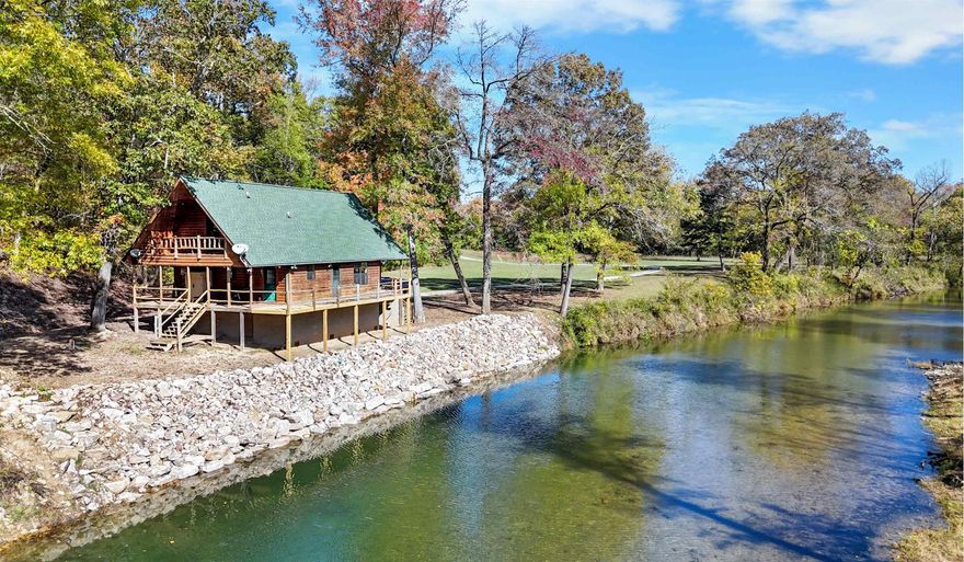 CREEK-CABIN-ACREAGE! This place has everything! This FULLY FURNISHED cabin is located on 12 acres with direct access to Piney Creek, a year-round creek with excellent smallmouth bass fishing, kayaking, and swimming. Step inside to an inviting open floor plan featuring large windows offering stunning views of the creek. The kitchen features custom cedar cabinetry. The master suite, located on the main floor, includes a bedroom and attached full bathroom. Upstairs you'll find two open bedrooms, a full bathroom, and a balcony overlooking the creek. Enjoy the peace and seclusion of being located at the end of a long private drive, surrounded by nature. There is a covered front porch and a deck that extends to the back, perfect for grilling & gatherings. The 12 acres includes a mix of open ground, woods, and even a seasonal waterfall, providing endless opportunities for exploring and outdoor fun! Call to schedule a showing today!