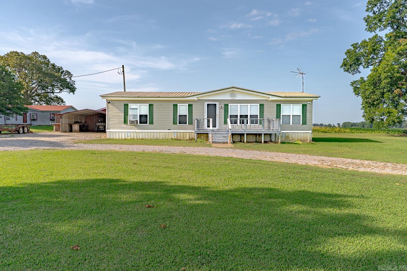 Welcome to Market 35288 Loudermilk Road of Tyronza, Arkansas. This is one you'll want to call home. Situated on a .94 +/- acre level lot is a 1995 built customized manufactured home wrapped in vinyl, topped with a metal roof, and accented by shutters, gutters, and a wood deck off of the front and back. The interior of this Ranch Style property features 1,456 sf of well laid out living space over a split floor plan that includes: a large living room w/ vaulted ceiling, dining room, kitchen w/ custom island and gas range, Master w/ en-suite w/ walk-in shower, spare wing with 2 generous guest bedrooms and guest bathroom w/ shower/tub combo, and large laundry room. The exterior holds a detached 2 car carport, (half) floored & wired shop w/ lean-tos, storm cellar, 4 inch well for the garden, half circle drive, cozy swing, and mature Pecan tree. You'll love the farm views and country setting w/ easy access to I-555. Conveniently located less than 40 miles from Jonesboro and Memphis. Priced to sell, move in ready, w/ furnishings and equipment negotiable. Call today to schedule your tour and make this house your home.