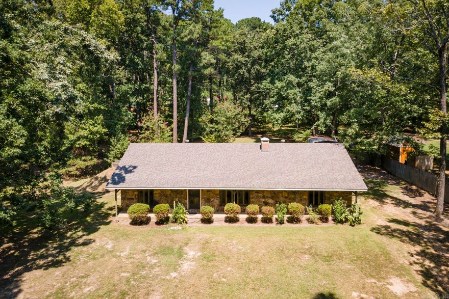 This one owner home is a true gem - thoughtfully cared for and ready for its next chapter.  Whether you are drawn to its 1970's charm or envision modern updates, the solid construction and timeless details make it an incredible opportunity!  This lovingly maintained ranch home sits on 3 lots with over an acre of land in a peaceful setting, privacy & mature trees.  Solidly built on a floating foundation, the home offers both character and durability.  You'll love cozying up to the stunning floor-to-ceiling rock fireplace, enjoying the beautiful and serene setting with walls of windows that fill the space with natural light in the spacious living room with vaulted ceiling with exposed beam.  Whole home generator, inground storm shelter and security system provide comfort and peace of mind.  Refrigerator and washer and dryer stay with the home.  A rare find for buyers seeking a well-built home in a peaceful setting with room to expand or create your dream outdoor retreat!