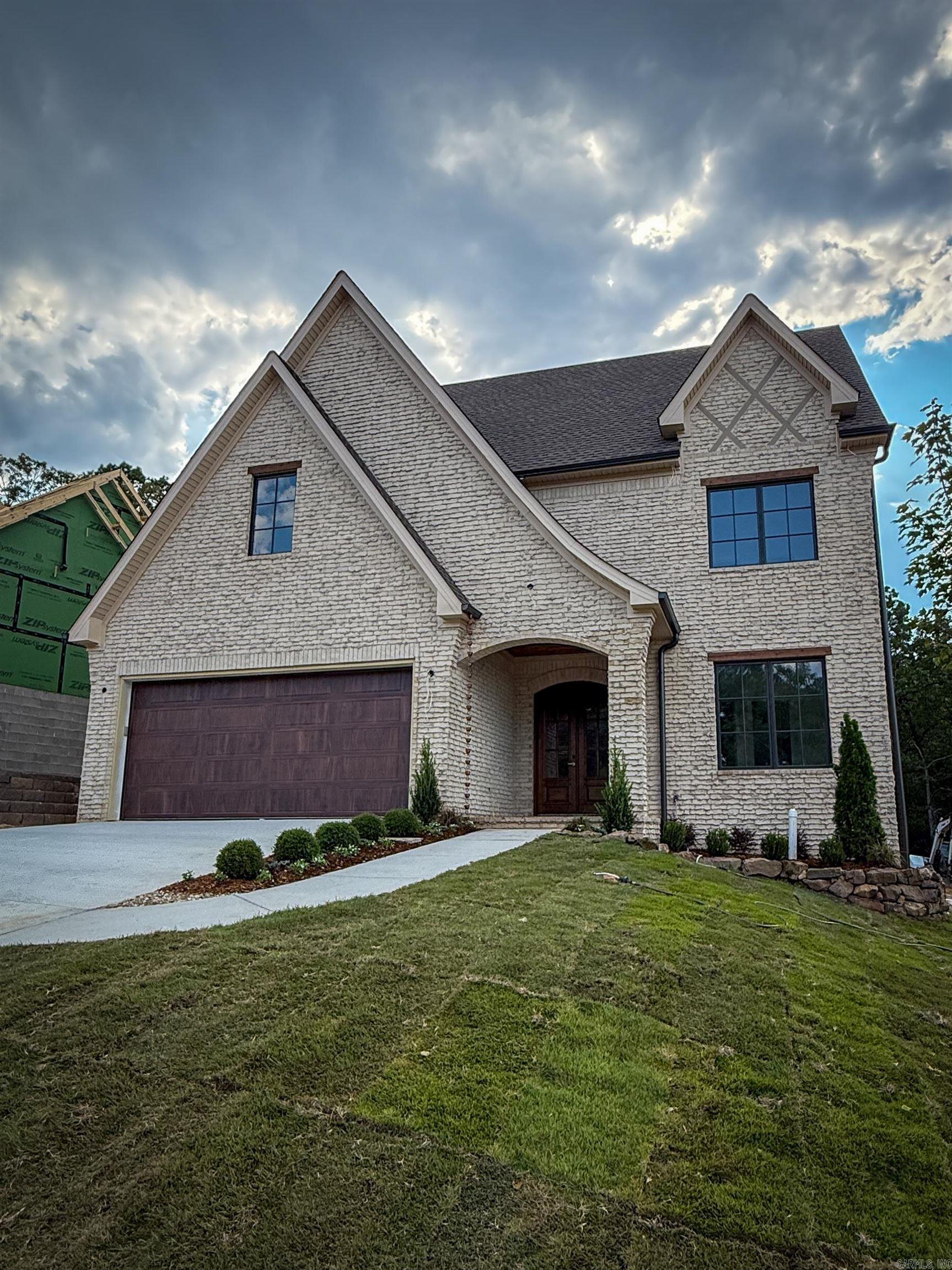This custom-built French-style transitional home blends timeless elegance with modern comfort, offering 5 bedrooms, 3.5 baths, and over 3,900 sq ft in Chenal. Showcasing weeping mortar brickwork and high-end finishes throughout, the design is elevated by Sierra Pacific wood-clad windows that flood the home with natural light. The gourmet kitchen with a large pantry, two laundry rooms, and an extra-large bonus space provide both luxury and functionality. Dog lovers will enjoy dedicated indoor and outdoor bathing areas along with a secure built-in space for their pets. With a quiet backyard green space for relaxing or entertaining, and just minutes from shopping, dining, and Pinnacle Mountain, this home truly has it all.