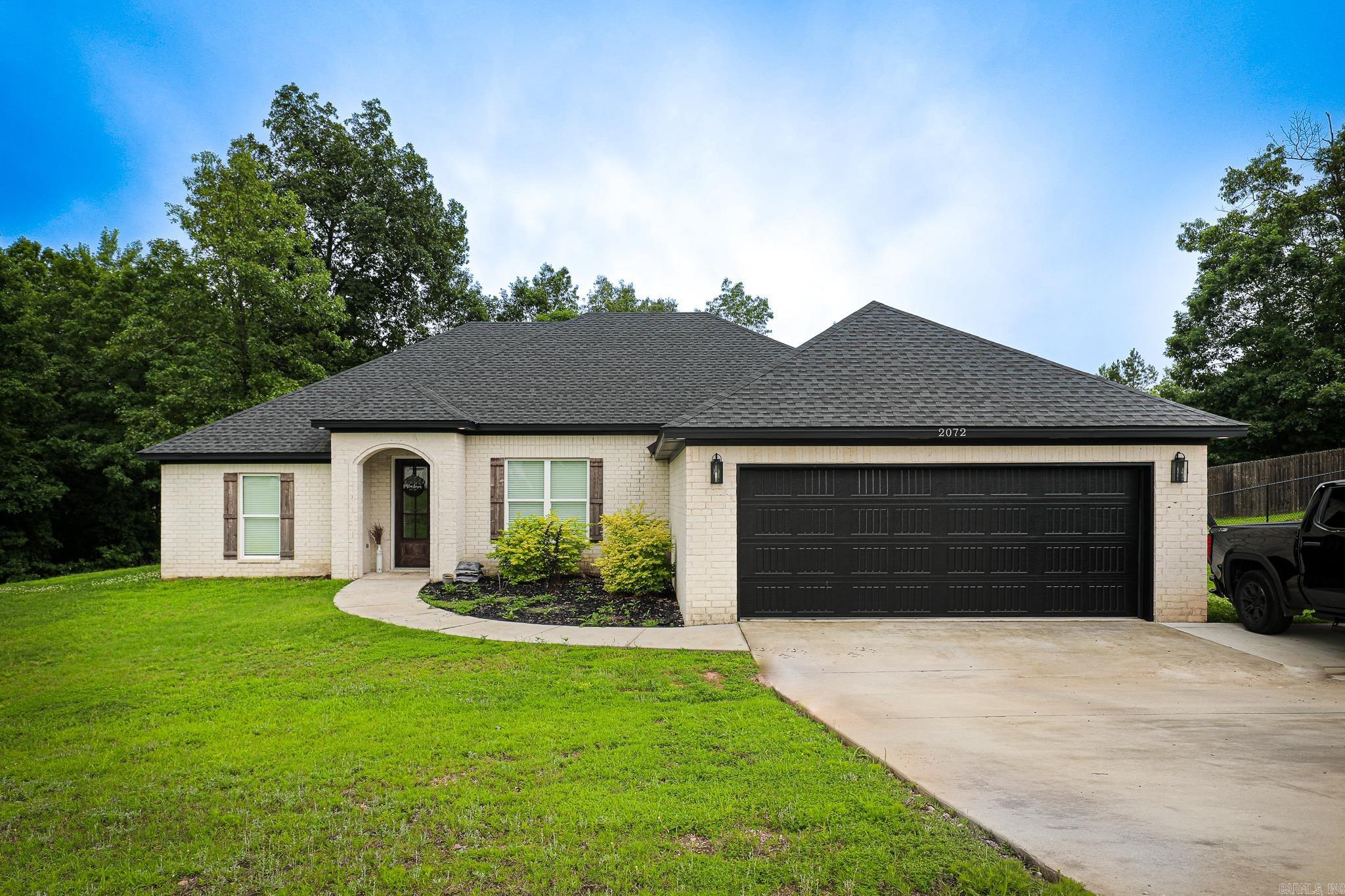 Welcome to 2072 Creekwood Circle — a stunning 3-bedroom, 2-bath home nestled on a full acre. Built in 2022, this thoughtfully designed home offers over 1900 square feet of open living space with high ceilings, recessed lighting, and durable wood-look. The spacious living room features a beautiful oversized windows that let in tons of natural light, a cozy fireplace, with an open concept kitchen that is a showstopper with granite countertops, stainless steel appliances, a large island with bar seating, and the versatile dining spaces that offer room for entertaining. The primary suite is tucked away for privacy and includes a double vanity, soaking tub, separate shower, and a huge walk-in closet. The secondary bedrooms are generously sized and share a stylish hall bath. You’ll also love the mudroom off the garage, spacious laundry room. Step outside to a fully fenced backyard with a covered back patio wooded views and room to roam. This home truly has it all—modern finishes, functional layout, and room to grow.