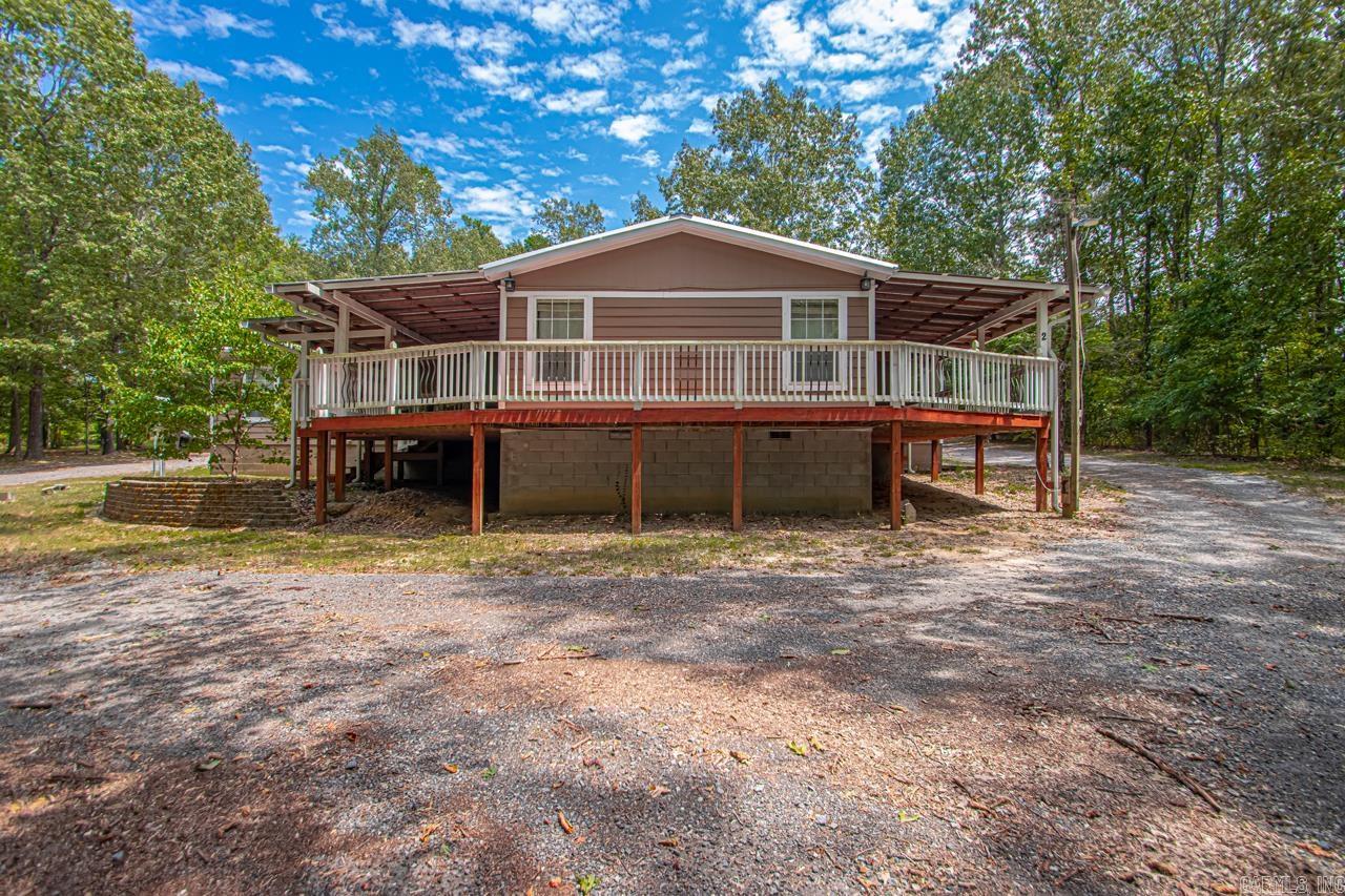 Nestled on approximately 4.50 acres of land, this 4-bedroom, 3-bathroom residence features covered porches at the front and back, ensuring ample porch space and privacy. The home boasts a large den addition, spacious dining area, and office area. The kitchen has been completely renovated, showcasing solid surface countertops, newer appliances, a gas stove top utilizing propane, wall oven, microwave, and a pantry with a barn door. The dining room features a wood-burning fireplace, which could also serve as a secondary living room. The primary bedroom is situated off the den, with the primary bathroom offering an updated design, complete with a freestanding Jacuzzi tub, solid surface shower, and walk-in closets. The split-bedroom plan provides three additional bedrooms on the opposite side, accompanied by a hall bath and a jack-and-jill bath between two bedrooms. A 3-car garage is attached to the home, complemented by a storage building measuring approximately 30x50. This well-maintained property offers an abundance of trees and privacy, making it a rare find. Schedule your showing today!