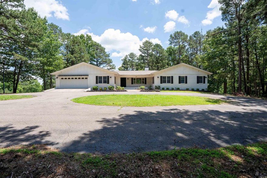 A rare blend of space, seclusion, and flexibility..this 3.27 acre estate offers luxury living.  Updated 4 BR, 3.5 BA home features 3,340 SF on the main level with an open-concept layout, wood burning fireplace with gas logs and a flexible office or 5th Bedroom.  The primary suite includes a spacious ensuite bath, oversized walk-in closet, additional closet, and deck access.  Enjoy lake views from the back deck and  access to Lake Moore for fishing and peaceful outdoor enjoyment.  A circular drive leads to a 2-car garage, while the 3,340 SF walkout basement with garage doors offers generous storage and room to expand.  VRBO permitted. Ideal for personal use, retreat or investment. Agents see Remarks.