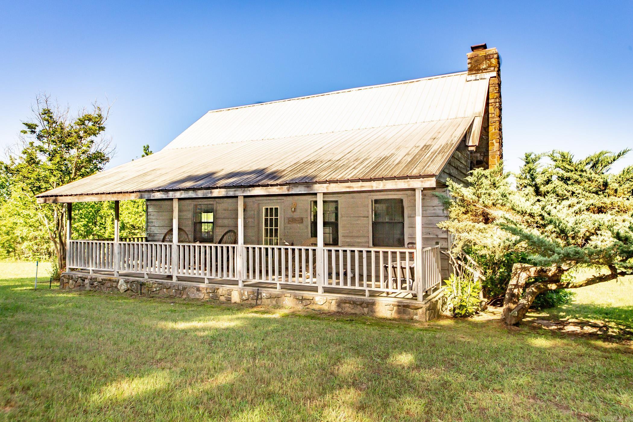 Discover your own private haven set amidst the stunning rolling hills of Clinton/Crabtree, Arkansas. This picturesque farm offers a rare blend of open pastures and tranquil wooded areas, providing the perfect setting for peace, relaxation, and a true connection with nature—where the only sounds you'll hear are the songs of the birds. The property features a charming farmhouse full of rustic character, complemented by a versatile barn with comfortable living quarters, ideal for guests or extended family. An additional historic farmhouse, brimming with potential, awaits your vision and restoration. Enjoy ample space and endless possibilities with three scenic ponds, three barns, and a well-equipped corral—perfect for horses, livestock, or recreational activities. Modern conveniences blend seamlessly with countryside charm, as fiber internet and city water are already on site. Whether you dream of a working farm, a serene retreat, or a family homestead, this remarkable property invites you to step back in time while enjoying the comforts of today. A hunter's paradise. Schedule your tour and experience the ultimate in Arkansas country living! Mineral rights do not convey.