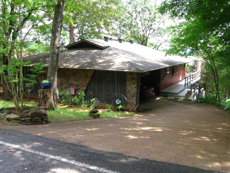 LAKEFRONT ON GREERS FERRY LAKE WITH VIEW OF SUGARLOAF!!!!  Take a look at this great home.  Main level has large living-dining area with fireplace & a wall of windows to take advantage of the view of water & Sugarloaf.  The kitchen, 2BR, 2 Ba, & laundry room are also on the main level.. Kitchen has tile backsplash, side-by-side refrig/freezer, dishwasher & disposal. Nice washer/dryer also included. Flooring is "hand-scraped" hardwood, parquet (lower den), carpet in BRs.  An expansive deck provides enjoyable space out of doors, & was just painted 5/24.  The circular drive & pull-through carport give quick entry.  A spiral staircase takes you to lower level with a den/office space, & an electric wall heater. Also a shop!  Lower walk-out to another deck that was painted 5/24!, & yard.  Walk down the path all the way to water's edge & to the Boat Slip with lift.  The slip must be purchased with the house, & the price is additional $35,000.  Slip will be conveyed to Buyer at closing with Bill of Sale. The roof is Architectural shingle is 10-11 yrs. old.  The seasonal view is greatest from Fall until early May.  Limited lakeview mid-May to Sept.  Some furniture for sale. AGENT REMARKS