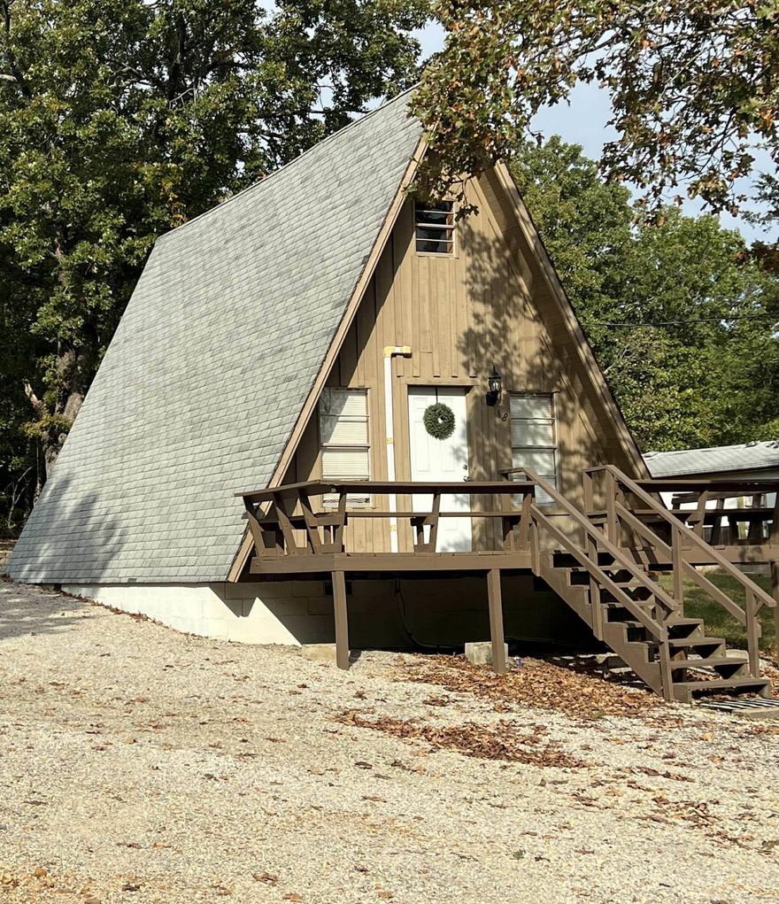 This Rustic A-Frame Cabin is located in Henderson, Arkansas, minutes from beautiful Lake Norfork & Lake Norfork Marina. 2 BR, 1 bath home sits on over a 1/2 Acre m/l lot in Lake Norfork Estate of Henderson. Just a short drive into Mountain Home, AR. for work, shopping & dining. The open format living area is showcased by a beamed-cathedral ceiling & beautiful hardwood floors throughout making the home easy to maintain.   The large lot allows plenty of parking and a 18'x30' carport to store boats & lake toys. On the main level is one bedroom and the bath. Upstairs is a 2nd bedroom that it great for extra guest. Recent updates: Installed 2023-Daikin 24,000BTU min-split with heat pump, Plumbing: All new Pex line installed in Spring 2025 & Septic pumped, 12'x12' lighted deck out back. The front deck has ready-made setting to enjoy morning Sunrises and out back to spend countless evenings to cookout on the lit-deck area. This is a must see! Contact the listing agent for more details.