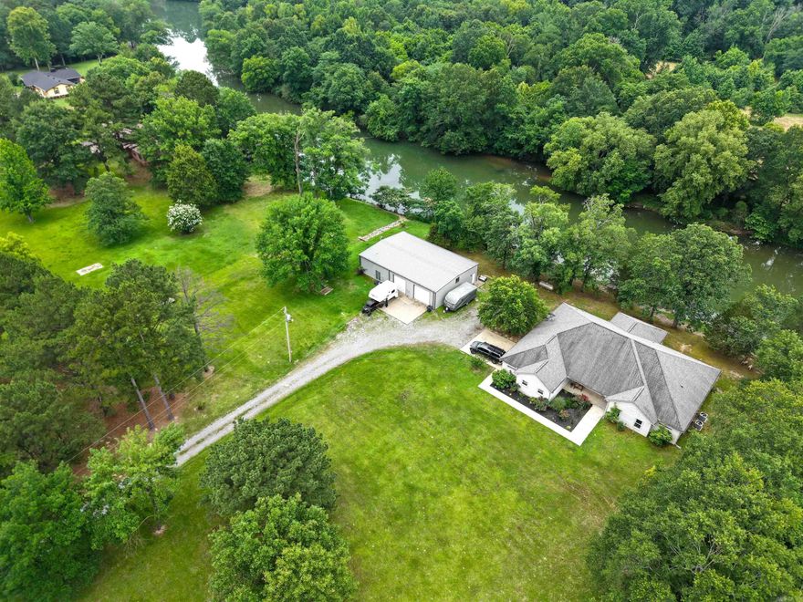One level custom built home has 3 bedrooms, 3.5 baths, formal dining room, eat-in kitchen, sunroom with a large side loading 2 car garage. The kitchen has 2 stoves, 3 ovens, loaded with cabinets, large island and a walk-in pantry. The main bathroom and guest bathroom has heated floors.  Laundry room has room for a refrigerator with ice-maker connection and freezer.  The 40x60 shop has 2 car garage and a guest quarters; offers a one bedroom, one bath, washer/dryer area, kitchen and living room. (Guest quarters SF not included in the 3071sf). Inside the shop, it has it's own a half bathroom 2 sinks and a storage room.  Located on the Mazarn River/Lake Hamilton with just over 3 acres. Come enjoy the peacefulness and wildlife from your windows.
