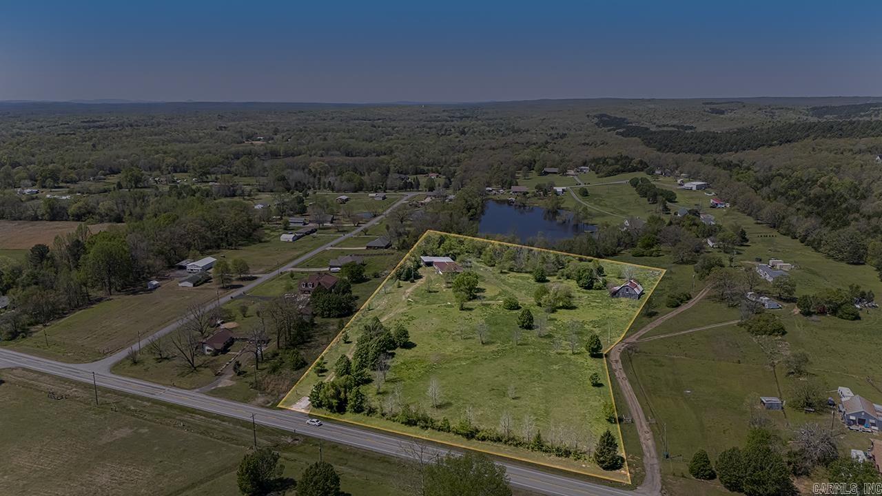 This property has now been cleaned up and is ready for a new project! 6.67 acres out side city limits. There is an old bar house that will convey at no value as well as a shop building. The property has electric, city water, 2 wells and septic system. Pond access at the rear of the property. Survey online. Come build your dream home!