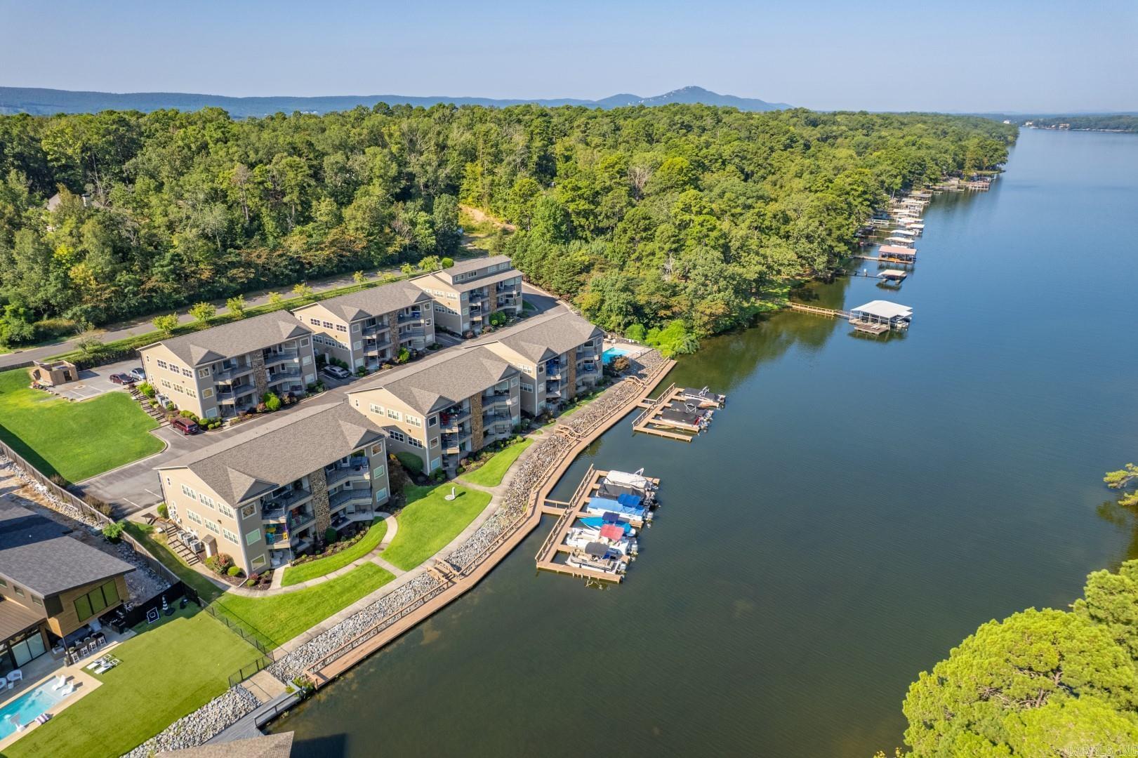 *MOVE IN READY* Welcome to your lakeside sanctuary at Woodlands on beautiful Lake Hamilton! This exceptional 2-bedroom, 2-bathroom condo on the second floor offers over 1,450 square feet with stunning northern-facing views of Lake Hamilton and Garvan Woodland Gardens. Step inside to discover an open-concept kitchen flowing seamlessly into spacious living areas, perfect for daily comfort and entertaining. The cozy gas fireplace adds warmth, while the private balcony—accessible from both the master bedroom and living room—offers breathtaking lake vistas and spectacular sunsets without harsh direct sunlight. Recently updated in 2025 with fresh tile flooring throughout (no carpet), new lighting, ceiling fans, toilets, and fresh paint, this move-in ready home features two generously sized bedrooms with ample natural light and two modern bathrooms. Refrigerator, clothes washer and dryer to convey. Woodlands offers amenities including a private pool on the lake shore and charming boardwalk perfect for fishing or evening strolls. With convenient bypass access, you’re minutes from Garvan Woodland Gardens, downtown Hot Springs, Oaklawn Racing Casino Resort, and Hot Springs National Park.