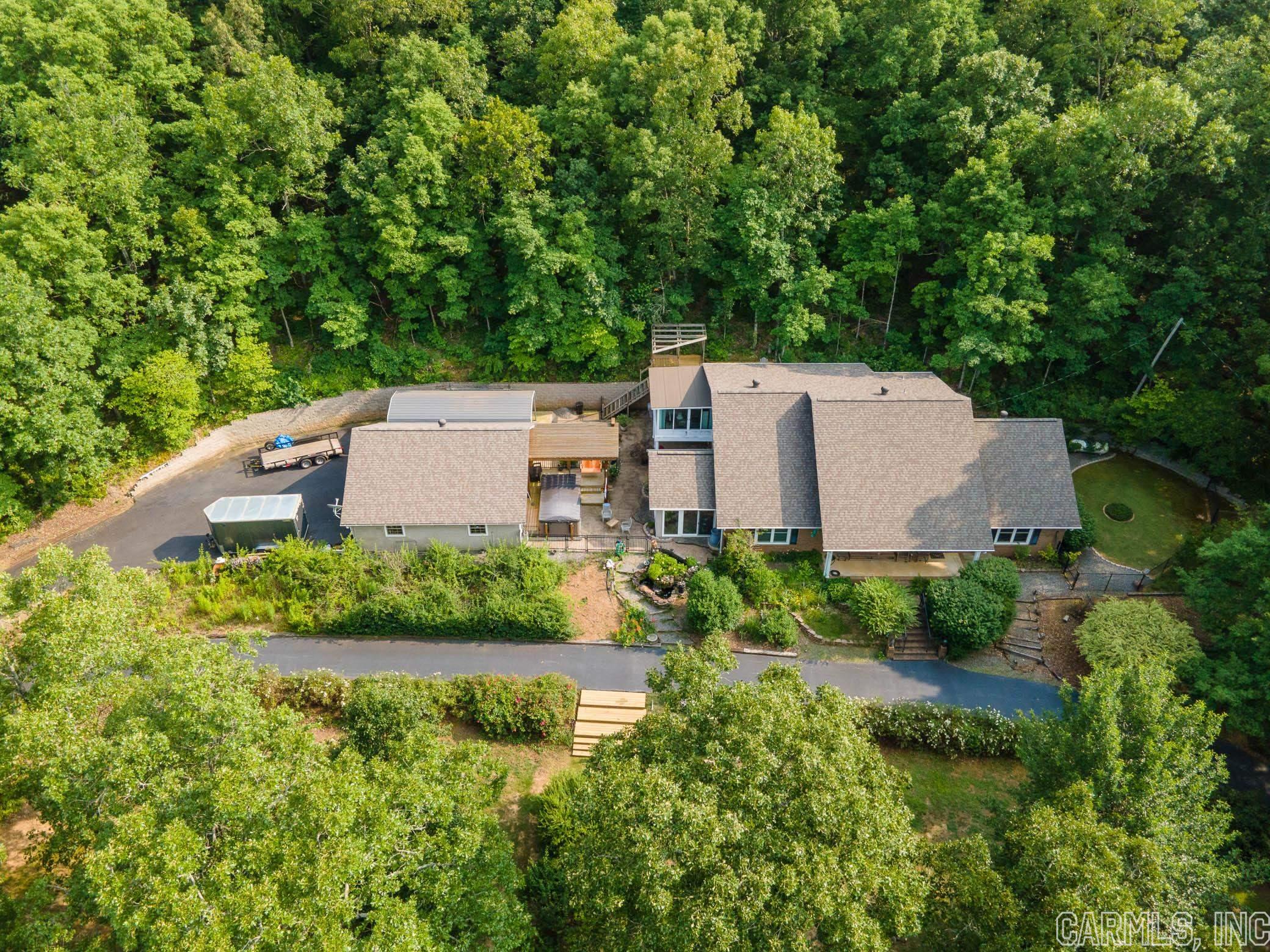 Welcome to your slice of heaven! Stepping onto this property you feel the peace and tranquility provided by the abundant natural gardens, tiered landscaping, and surrounding wooded area. Outdoor living spaces include a pergola with hot tub swim spa, large covered patio with waterfall feature, new upper level deck, and side courtyard. A large primary suite offers its own sunroom with floor to ceiling windows on three sides lending to a wonderful four seasons room. You will love the walk in Galaxy Deluxe Plus Steam Shower in the primary bath. Check out the link at homewardbath.com Upstairs you'll find a newly renovated bonus room to include its own kitchenette, full bath, and an upper level sunroom with a new deck across the back. This space has it's own private exterior entrance. You'll enjoy having the circle drive for all your friends and family when visiting. 30 x 30 - 2 1/2 car garage. This property is where you want to be at the end of each and every day to destress and rejuvenate. Only minutes to Conway and Jacksonville. Ask you lender about the VA Assumable loan to see if you may qualify. See Agent Remarks