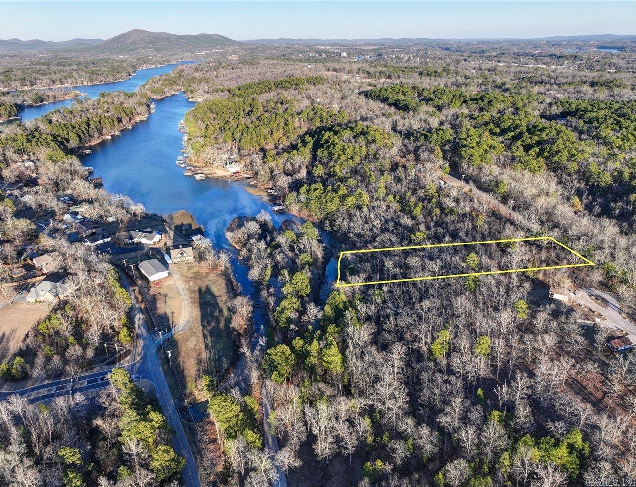 This lakefront lot is nestled in the sought-after Lake Hamilton School District, offering the perfect setting for your dream home. With approximately 100 ft on the lake, you will enjoy breathtaking views of both the water and the surrounding mountains. The location provides convenient access to key amenities, including medical facilities, shopping centers, restaurants, and the nearby bypass for easy commuting. Water and Sewer on Rock Creek Rd.