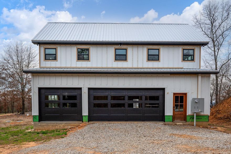 Ever dream of building your forever home on nearly 10 acres of hilltop paradise nestled into the woods? No need to cram into an RV or build a shop when you already have a 24 x 42 three car heated & cooled garage with an 812 sq ft apartment on site for your comfort.  Garage has 10 and 18 foot wide insulated doors, sink, and washer/dryer hookup with space for a small workshop. Additional 24 x 60 slab is adjacent for future shop.  Above heated and cooled garage is a 1 bed/1 bath apartment with kitchen and loft for additional space for office or beds.  Foundation for 2,000 sq ft basement with 12 inch thick walls and safe room is complete with plumbing rough ins. Trusses on site to complete your single or two story custom home. Owner was unable to complete dream home due to job relocation. Utilize existing house plans or customize your own if you wish. See photo for rendering. Agents please see remarks regarding showing instructions.