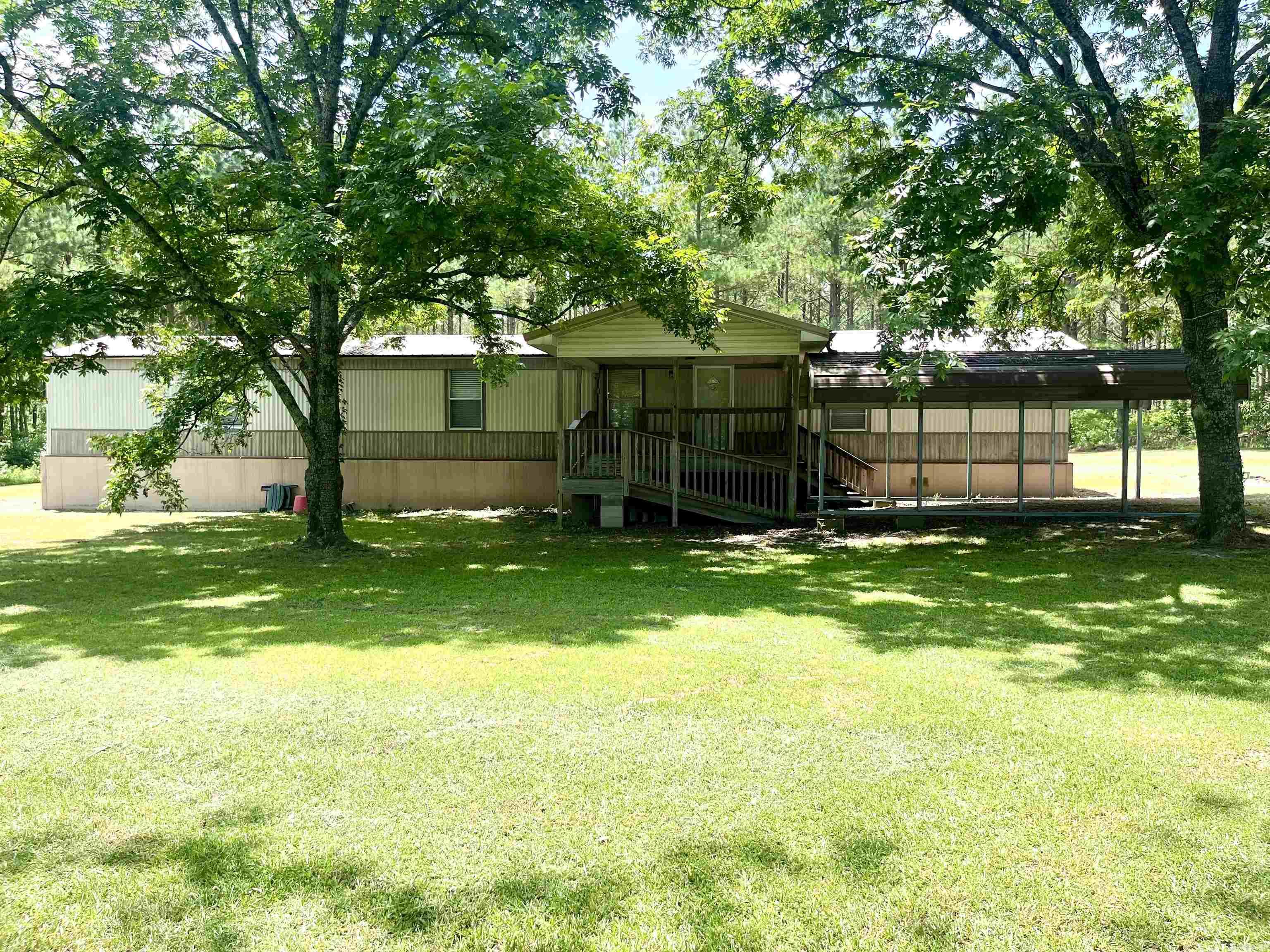 This property offers the perfect blend of comfort, convenience, and country charm. A cozy home on 3.27 acres, offering two bedrooms with walk-in closets and two large master-sized baths. Designed with an open floor plan, perfect for comfortable living and entertaining. Convenient all electric appliances, as well as being plumbed for Propane for an additional appliance or heater, if needed. A Large Covered Front Porch equipped with a ramp and steps for relaxing and enjoying the outdoors, with easy access for everyone. A single car carport and 20x10 outdoor shed and added covered storage for all your equipment and toys. This property is a great starter home with plenty of space to grow.