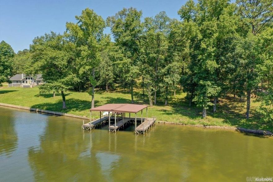 Discover the epitome of waterfront living with this exceptional 1.5-acre lot boasting breathtaking views of the main channel on Lake Hamilton. Nestled in a serene and prestigious neighborhood, this beautiful parcel offers an unparalleled opportunity to build your dream custom home amidst the tranquility of lakeside living. Spanning an impressive 192 feet of pristine lake frontage, this property features a meticulously constructed seawall and a private boat dock with a double boat slip already in place. Whether you're an avid boater or simply appreciate the serenity of waterfront living, this dock provides easy access to the sparkling waters of Lake Hamilton for endless day of recreation and relaxation. With construction-ready acreage, designing and building your ideal retreat is made effortless. Imagine waking up to stunning sunrise views over the tranquil waters, indulging in lakeside activities throughout the day, and unwinding against the backdrop of picturesque sunsets. Convenience meets luxury with city water readily available at the road, ensuring seamless utility access for your future lakeside oasis. Embrace the freedom to create your own architectural masterpiece.