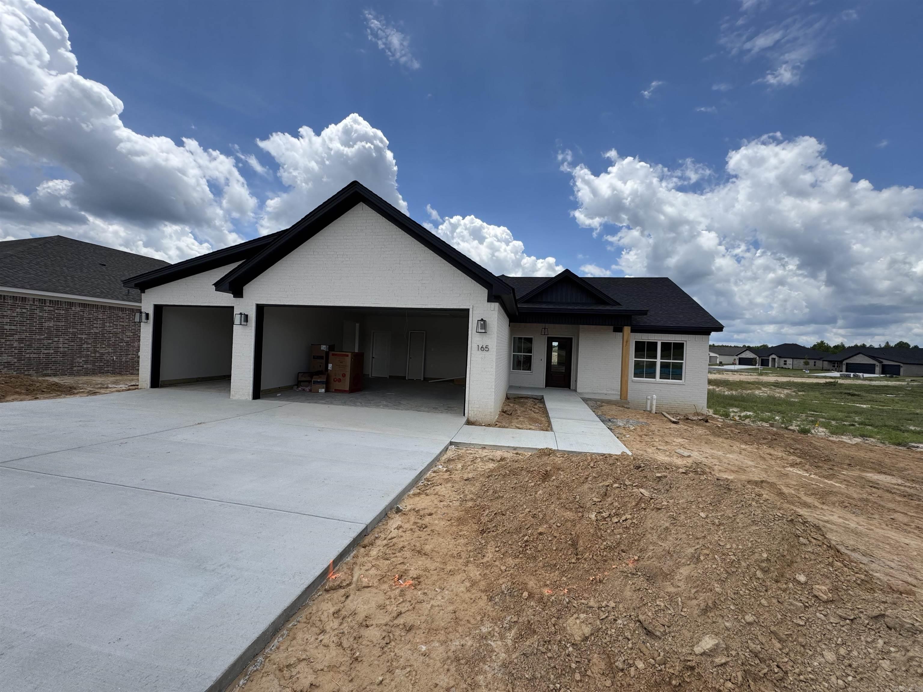 Introducing a stunning new construction traditional home designed for modern living. This residence features a three-car garage, three bedrooms, and two bathrooms, along with a dedicated office space. The master suite includes a luxurious walk-in closet and a spacious walk-in shower. The home showcases beautiful laminate flooring in the main areas, elegant tile in the bathrooms, and cozy carpeting in the bedrooms. The kitchen is equipped with quartz countertops and a gas range, perfect for culinary enthusiasts. Large windows throughout the main area allow for an abundance of natural light, creating a warm and inviting atmosphere. Additional features include Low E windows for energy efficiency, spray foam insulation, and a deck on the back porch, ideal for outdoor relaxation and entertaining. This home combines comfort, style, and functionality in a perfect package.