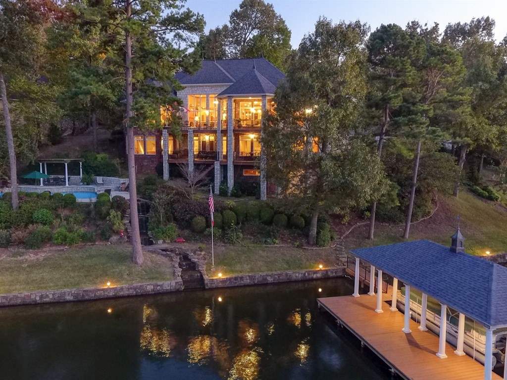 SUPERBLY DESIGNED CUSTOM Lake Home With 220' Waterfront On 2 Premier Gorgeously Landscaped Lots In Gated Neighborhood Of Fine Homes. Marble Inset Entry, Hardwoods & High Ceilings With Walls Of Windows. Formal & Informal Living & Dining Spaces, Designer Gourmet Kitchen, Luxurious Master Suite, Surround Sound Home Theater, His & Hers Offices, Home Gym & 4 Bedrooms, 2 Full Baths & 3 Half Baths. Breathtaking Pool Design, Covered Boat Dock w/Lift & PWC Lift, Lighted Seawall, 2 Waterfalls, 2 Wrap Around Decks and